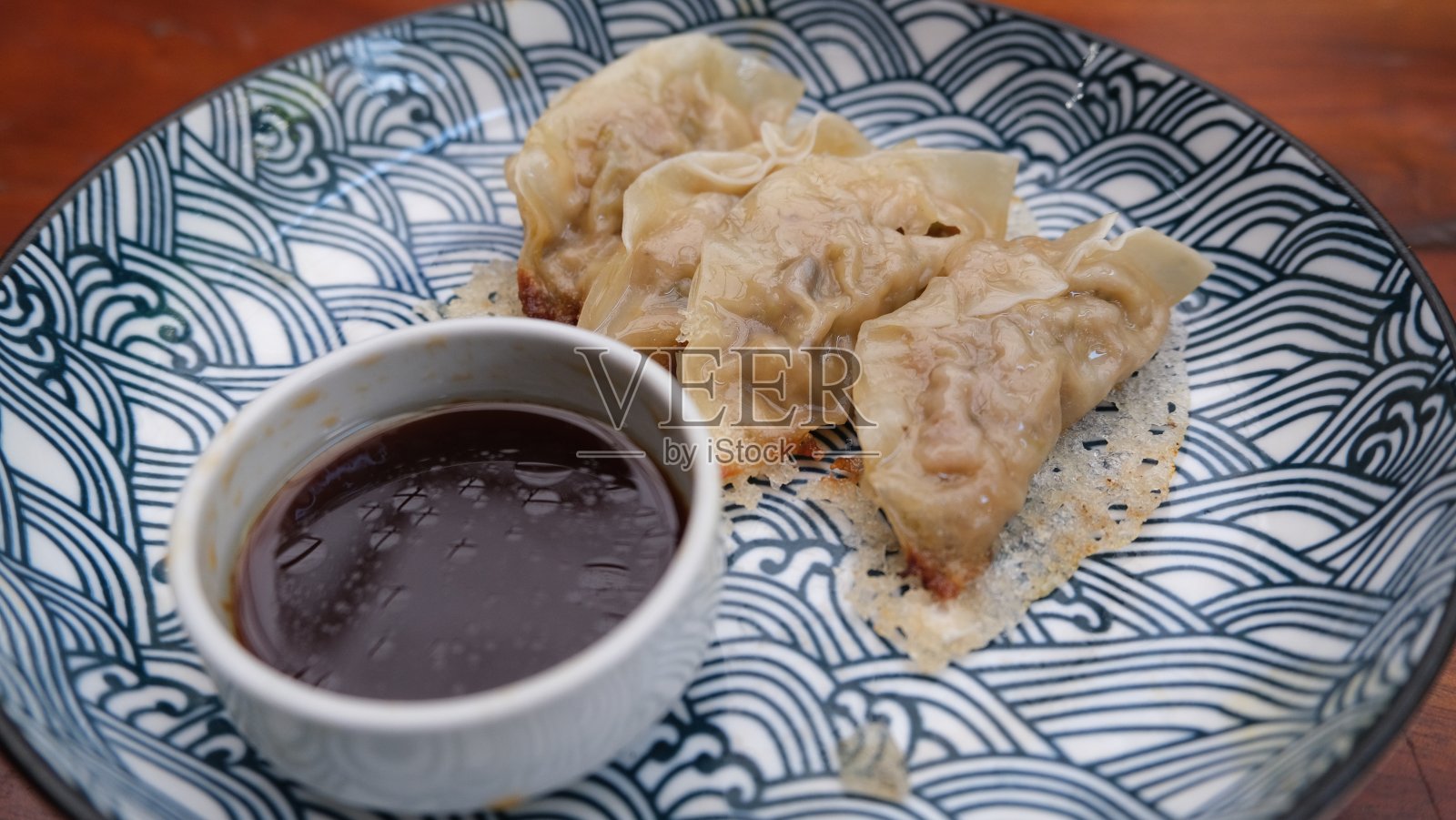 日式饺子，亚洲的烤饺子或煎饺子，盘子里有酱油照片摄影图片