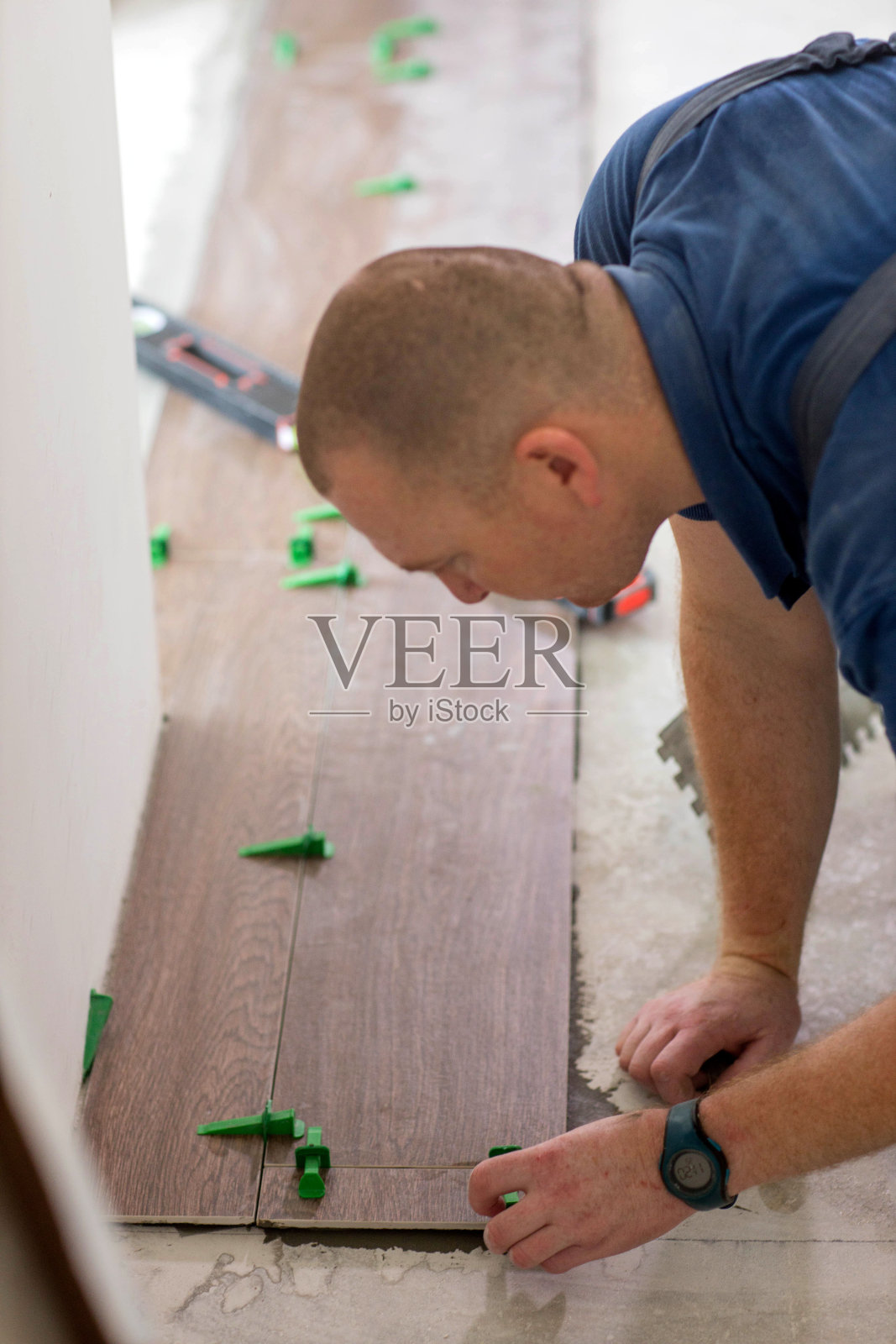 在新房子的地板上，瓦片夹在绑扎式瓦片找平系统中照片摄影图片