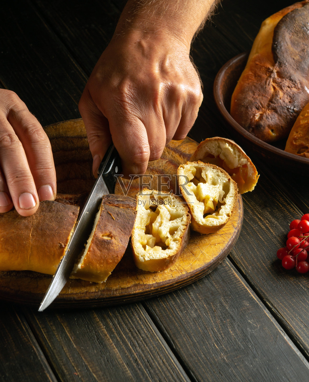 面包师正在切新鲜的苹果派，准备在节日餐桌上享用。美味的苹果派配香茶。照片摄影图片