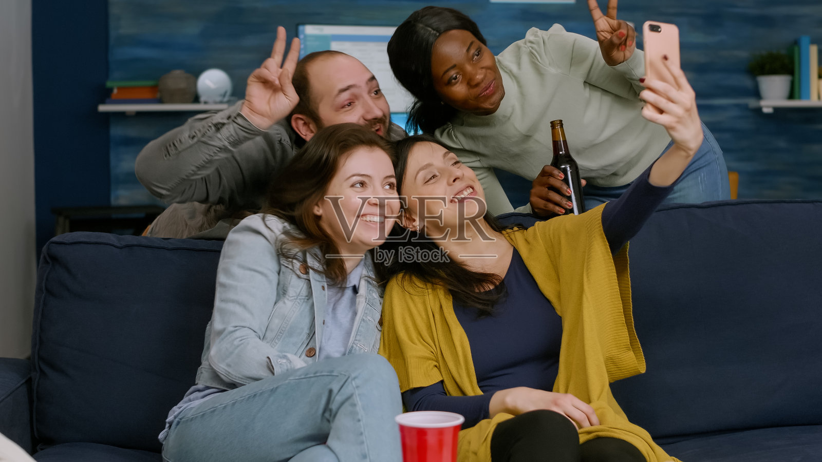 一群混血儿坐在沙发上用手机拍照照片摄影图片