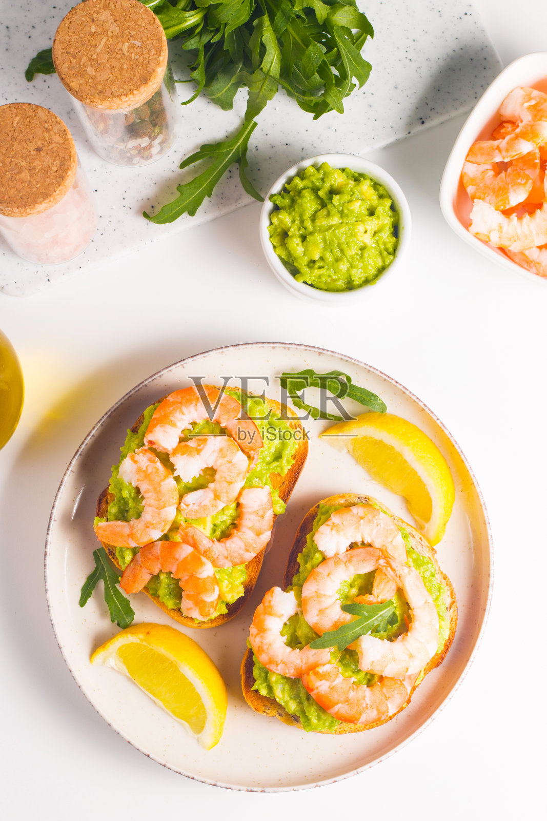 虾仁吐司配牛油果和柠檬。大虾。早餐的概念。意式烤面包。照片摄影图片