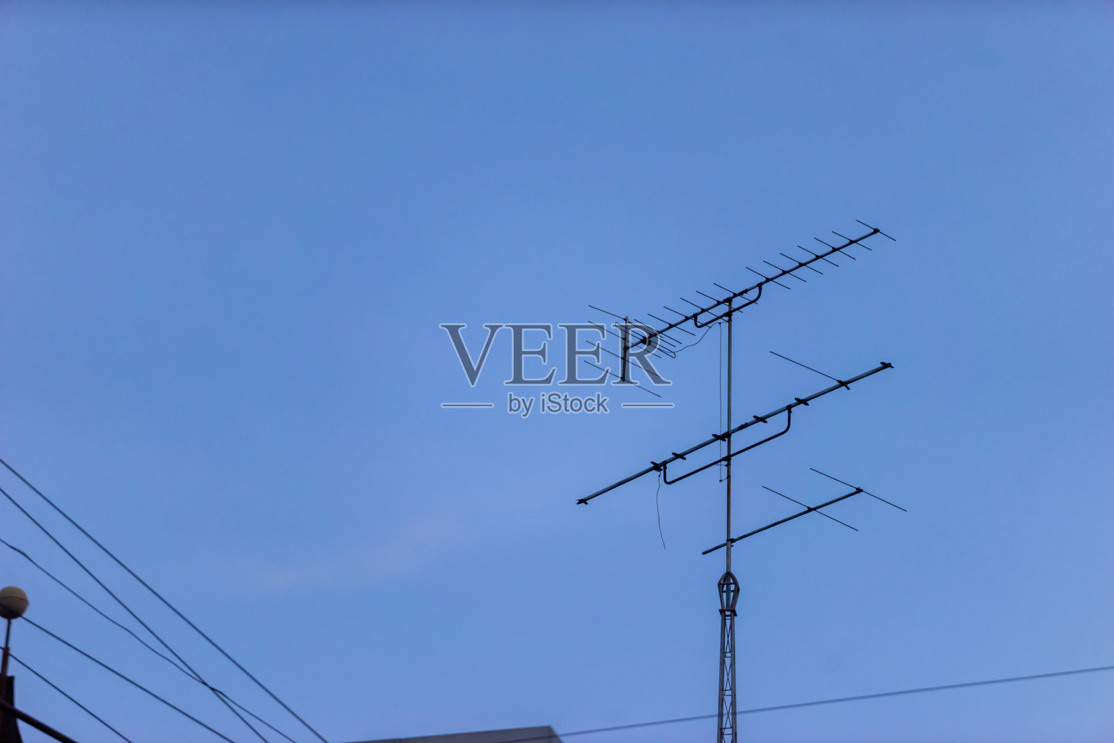 电视天线映衬着湛蓝的天空，照片摄影图片