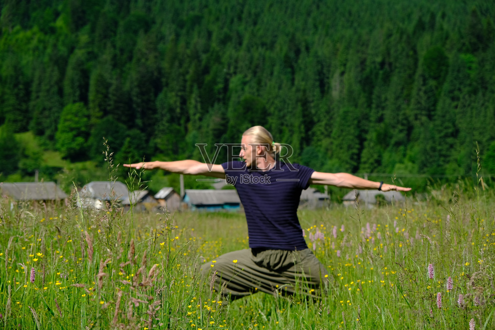 年轻人在绿色的大自然中练习瑜伽照片摄影图片