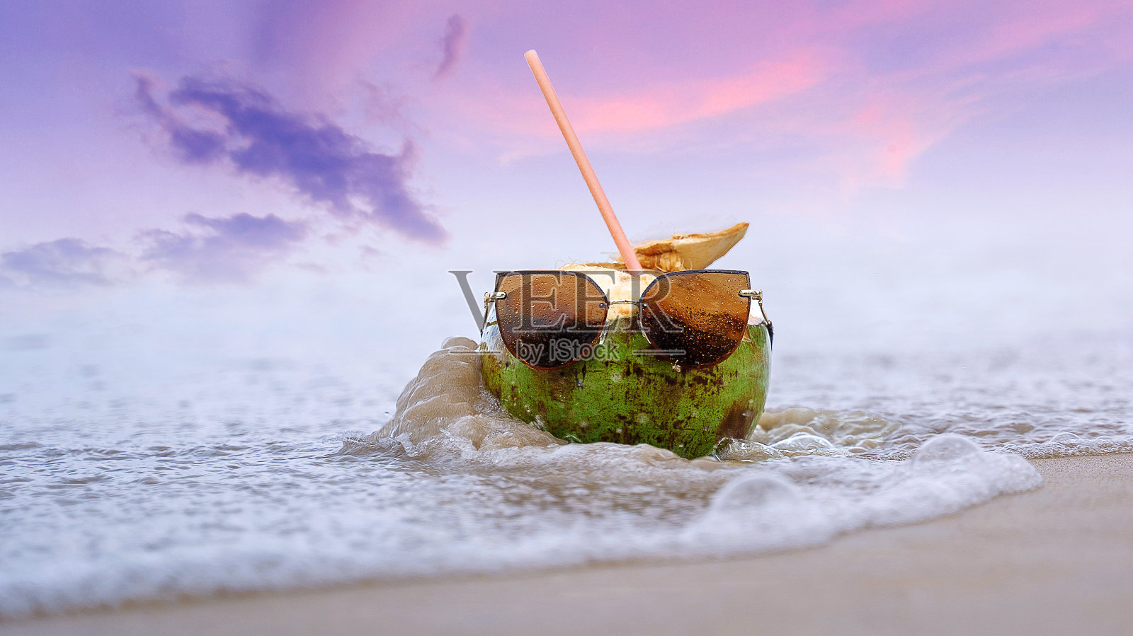 多汁的椰子站在温暖的海浪中，欢快的椰子在度假。照片摄影图片