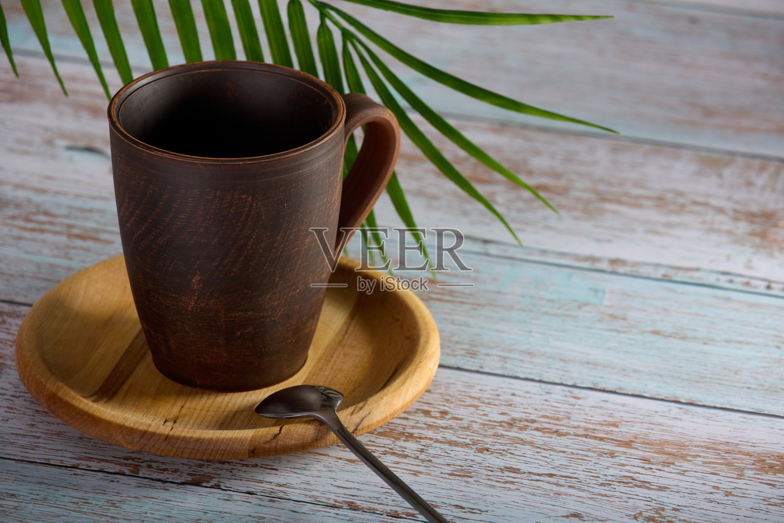 茶色咖啡杯立在木盘上，配有银匙照片摄影图片