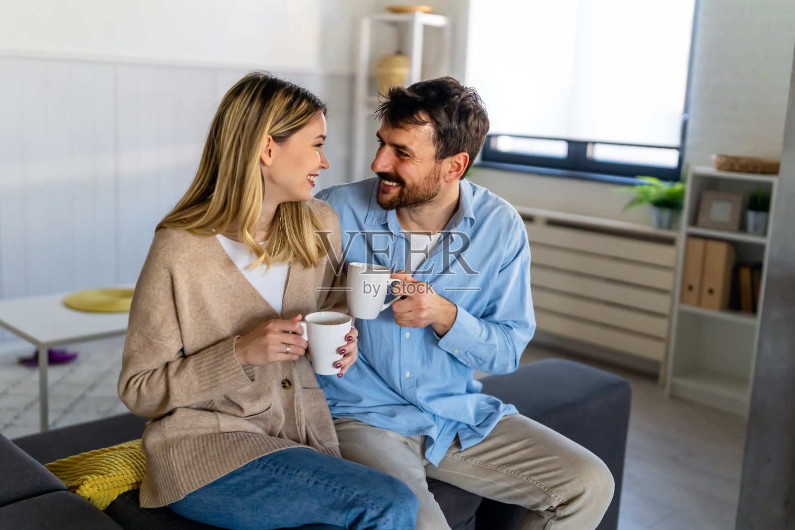 快乐的年轻夫妇在一起度过美好的时光，早上在家里喝咖啡。照片摄影图片