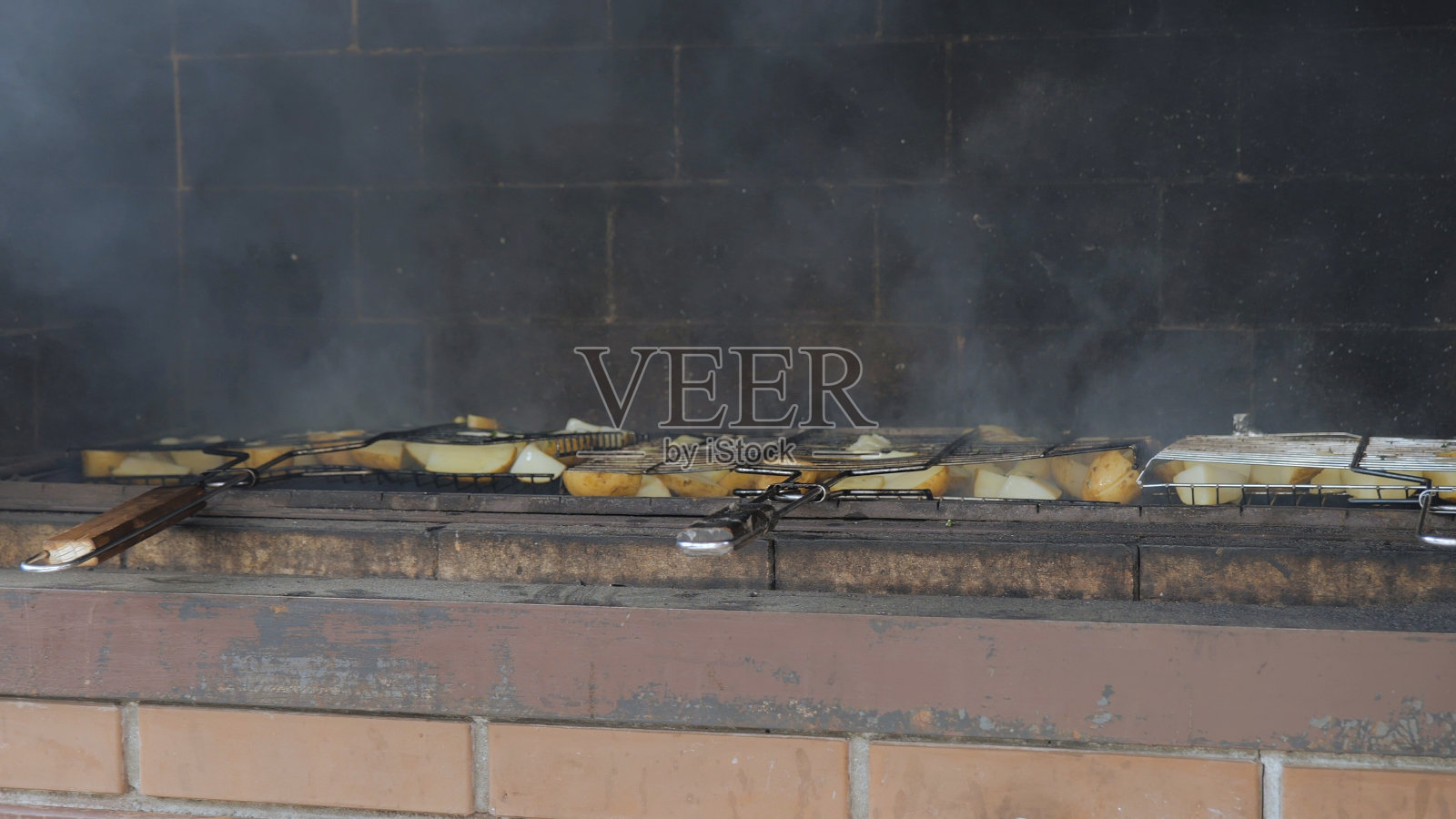 烤土豆。烧烤烤土豆和蔬菜。培根烤土豆。烤土豆配猪油串在烤串上。土豆和猪油。照片摄影图片