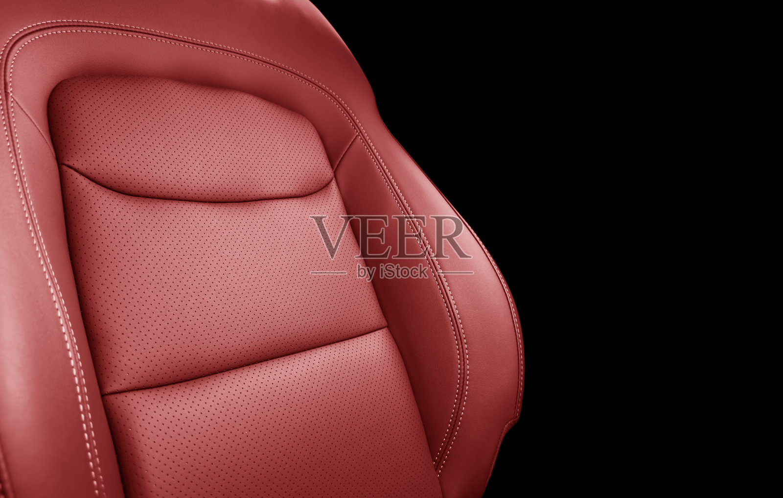 汽车红色皮革内饰。部分红色皮革汽车座椅细节与白色拼接。名车内饰。穿孔皮革座椅孤立的黑色。穿孔皮革。照片摄影图片