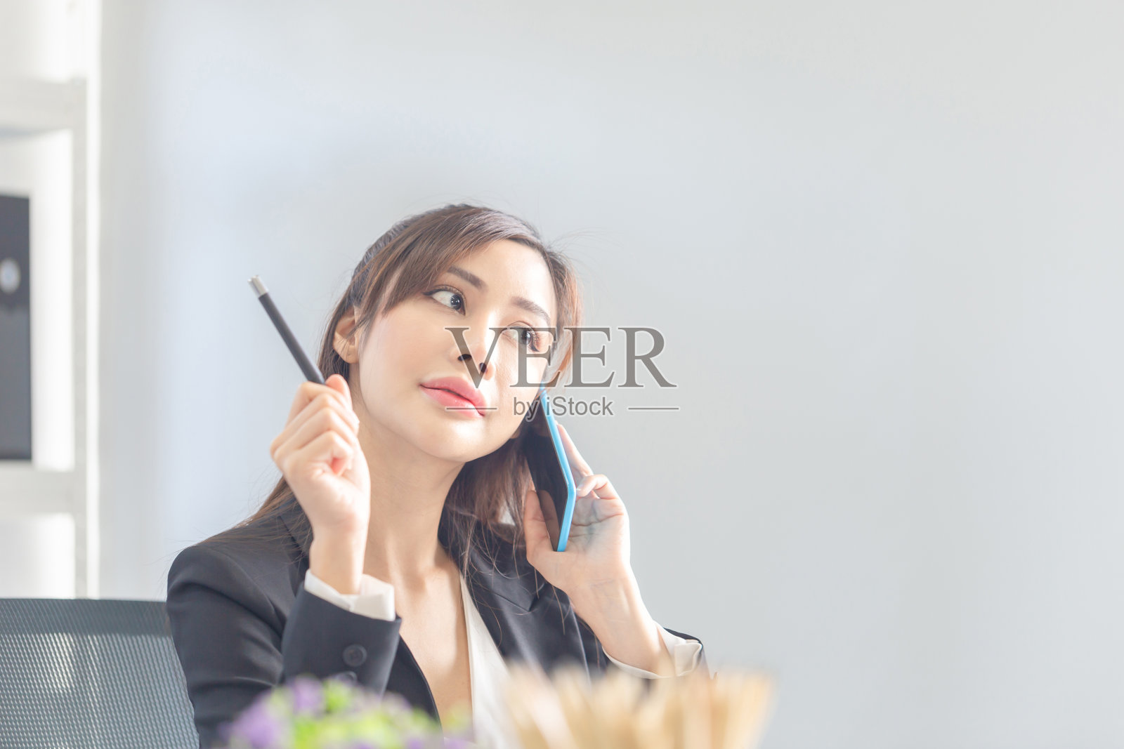 女商人在办公室使用手机。兴奋的漂亮女孩在办公室用智能手机，女人在办公室工作照片摄影图片