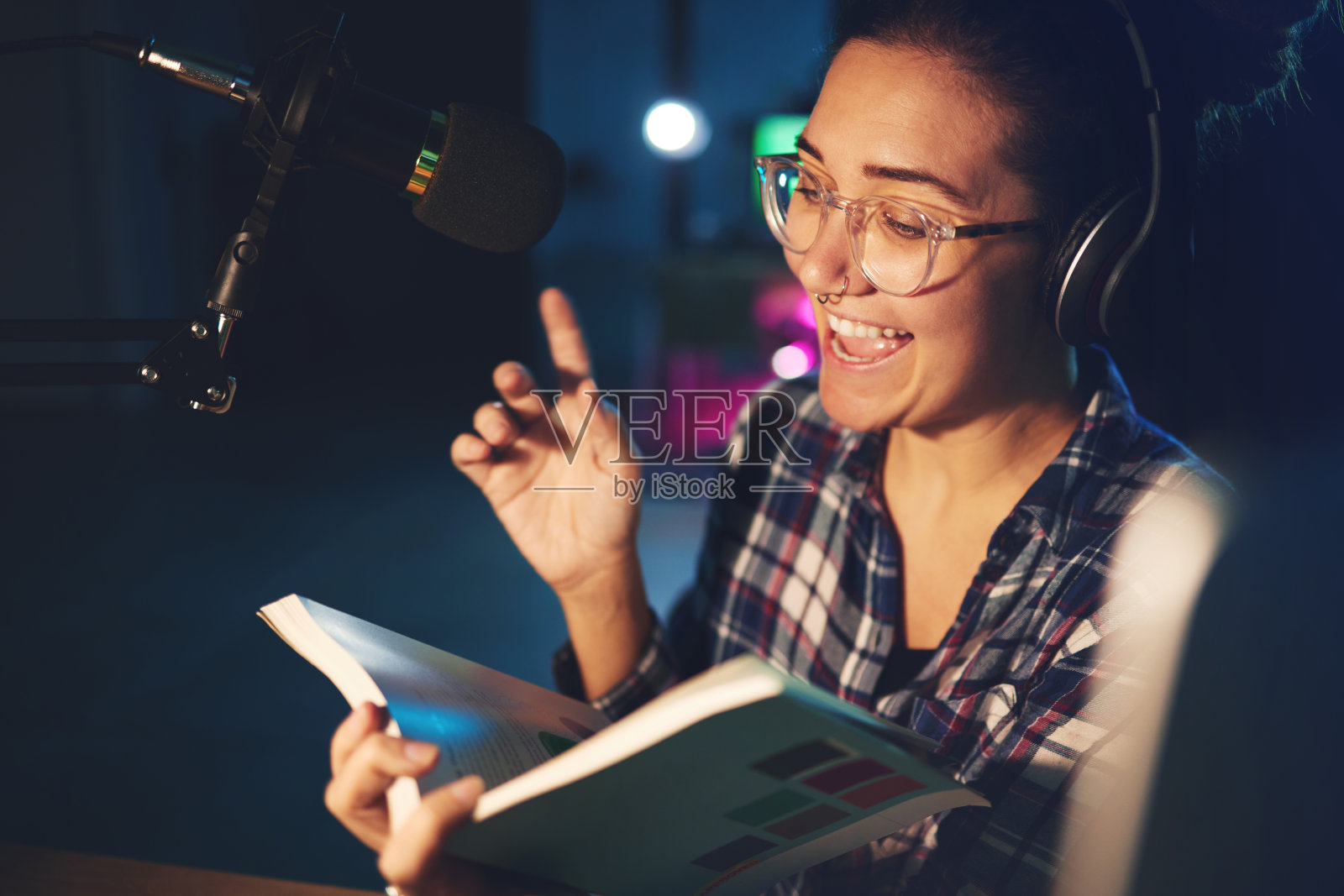 电台dj，主持人和女人在一个声音制作工作室快乐地读着一本书。耳机，录音和工作的女员工讨论网络播客和书籍谈话照片摄影图片