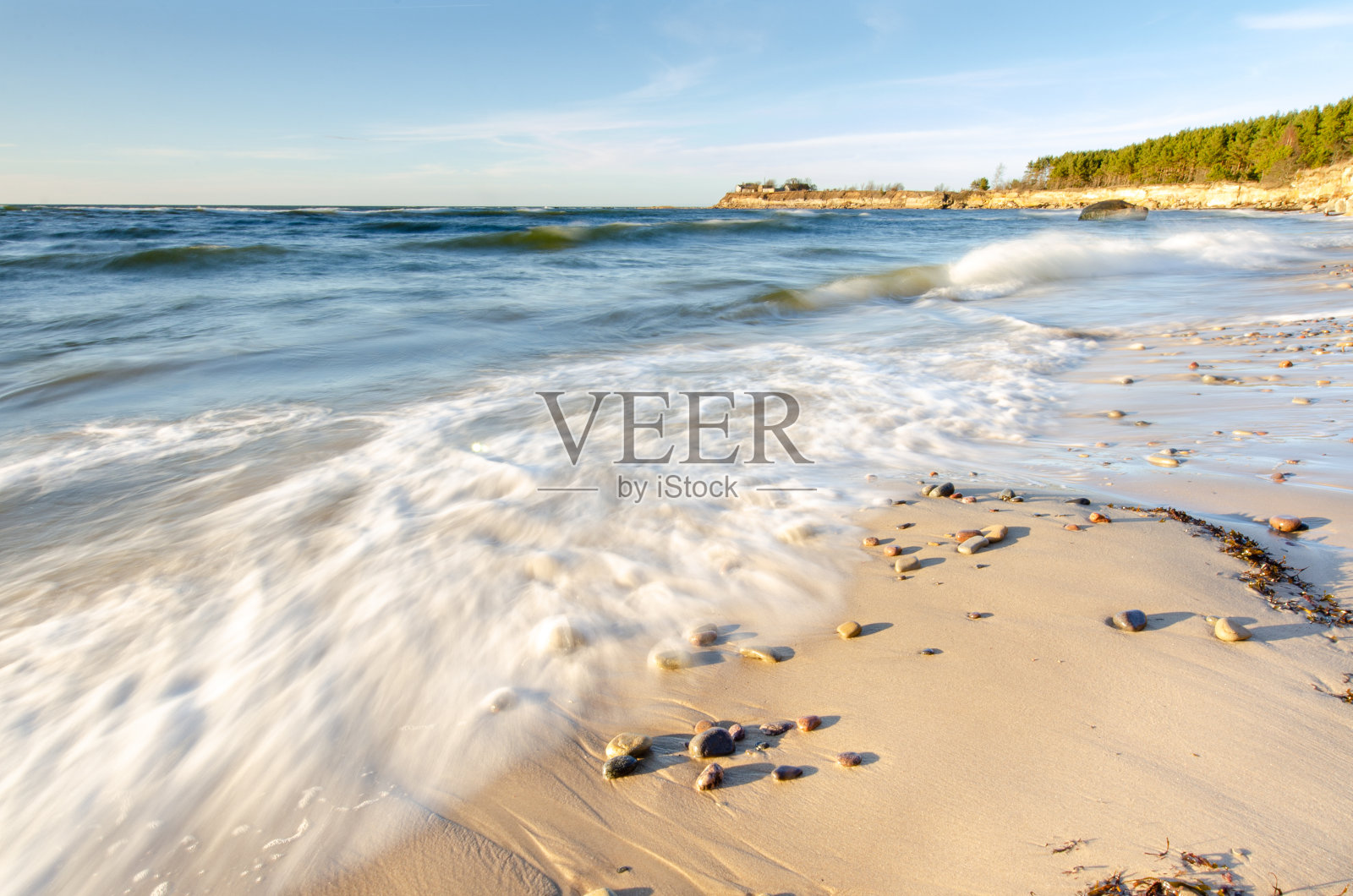 日落海滩，砂岩露头与运动波照片摄影图片