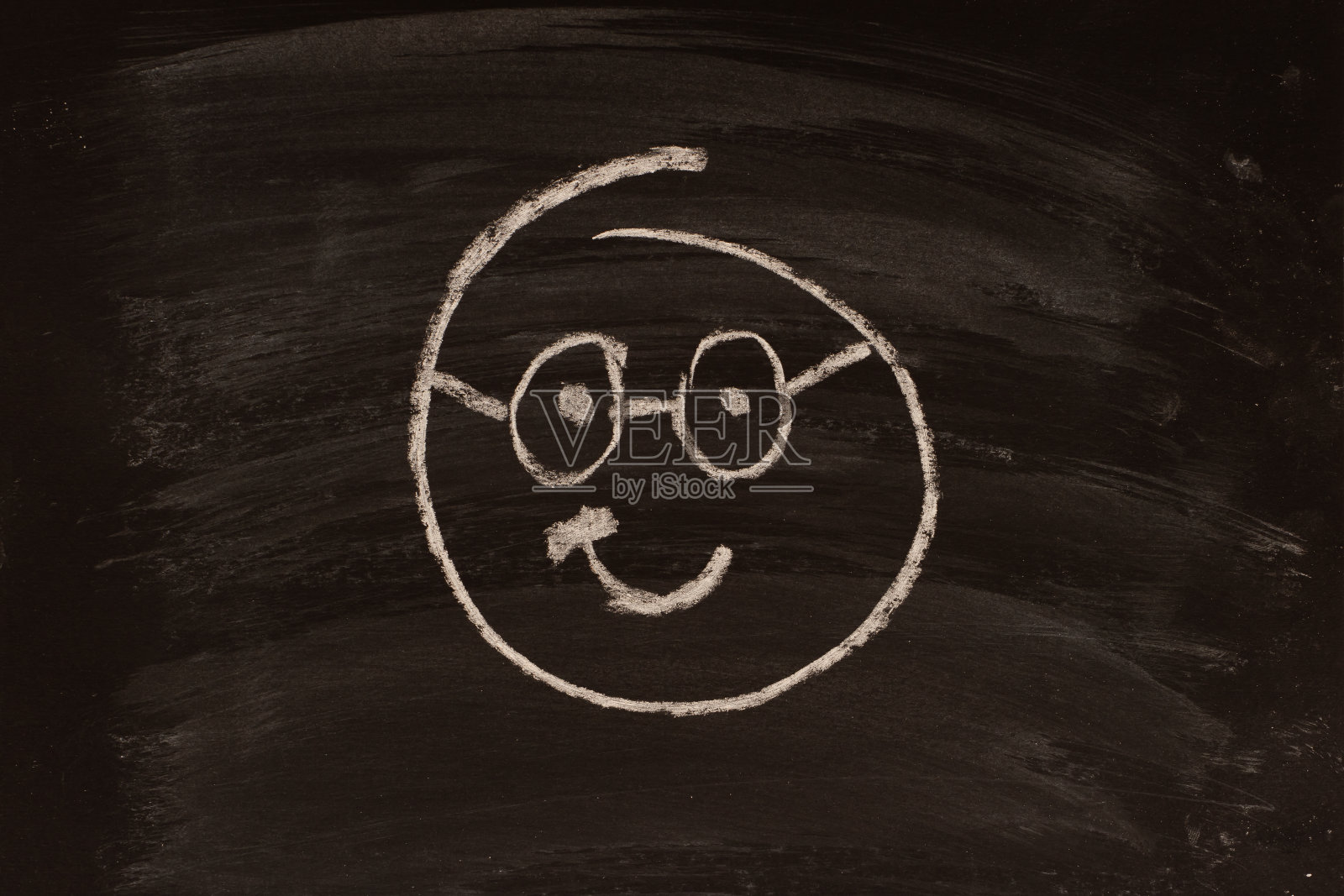 用粉笔在黑板上画的可爱的欢乐表情。照片摄影图片