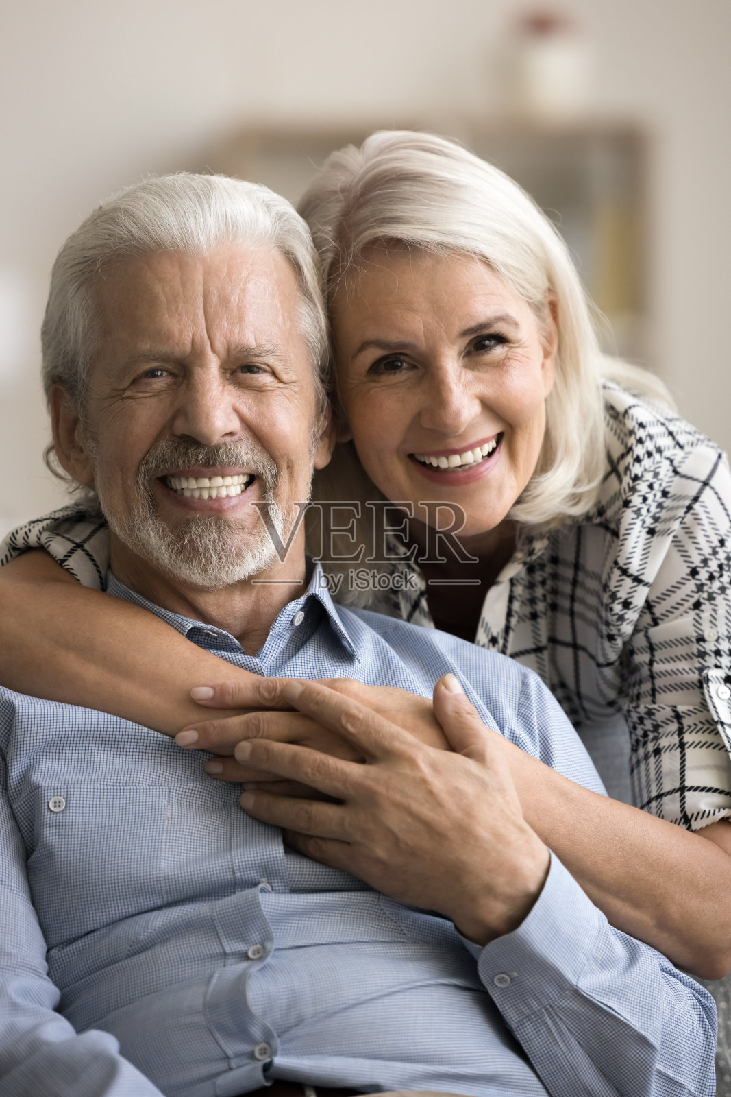 幸福快乐的成熟夫妇拥抱在沙发上的家庭肖像照片摄影图片