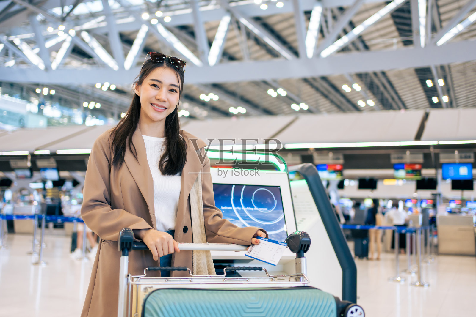 亚洲小女孩的肖像从机场候机楼走向登机口。迷人美丽的女游客乘飞机出国度假旅行感到高兴和兴奋。照片摄影图片