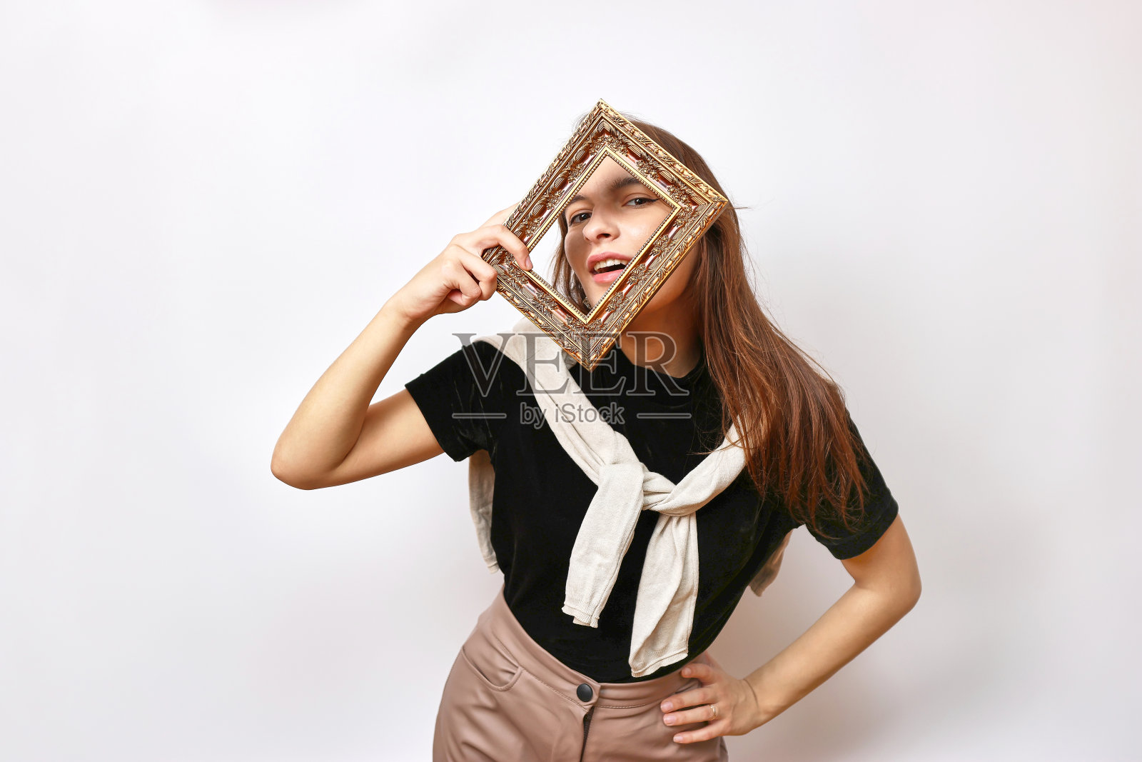 一个漂亮的女孩对着相机摆姿势，看着相框。照片摄影图片