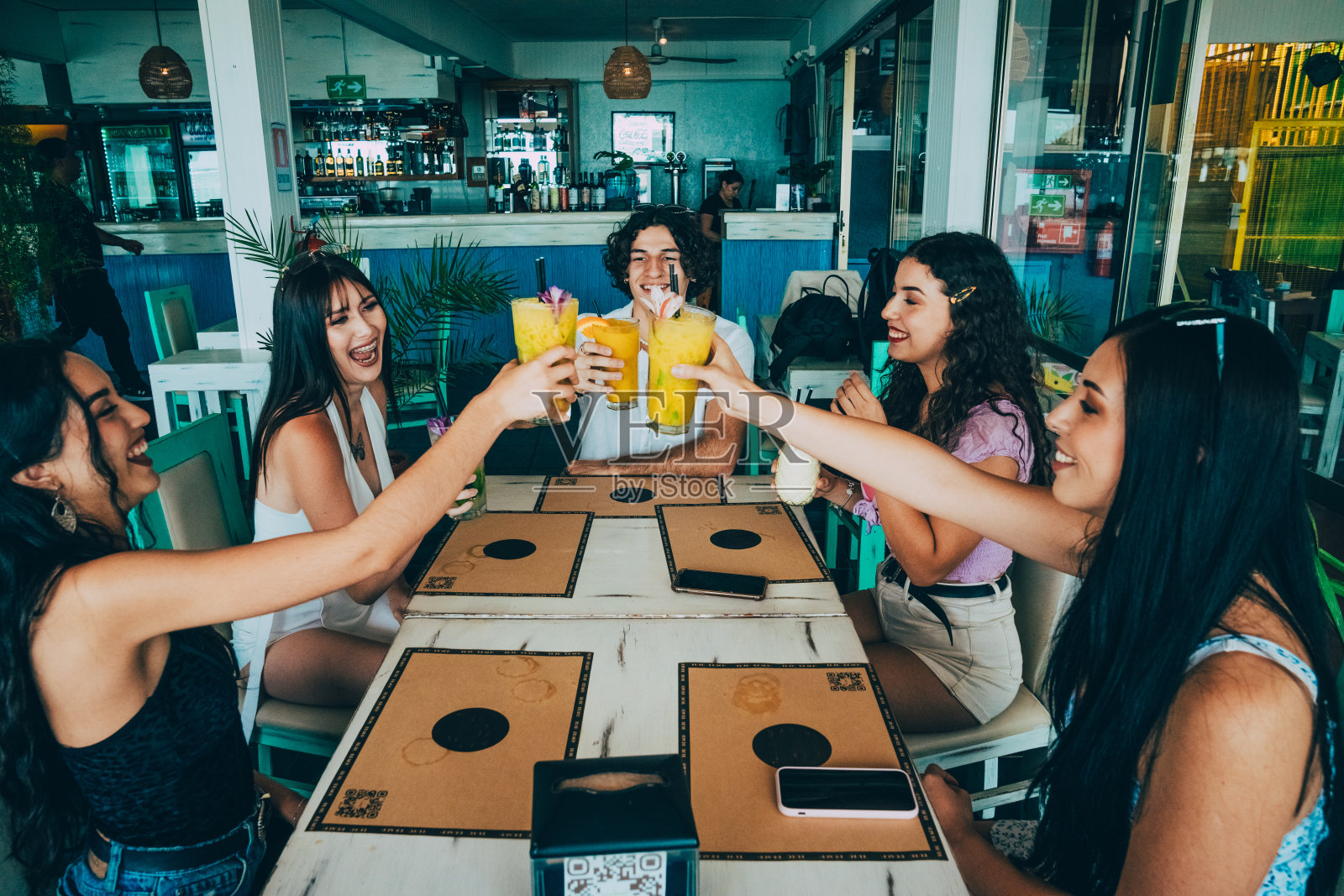 一群朋友一边喝酒一边微笑。照片摄影图片
