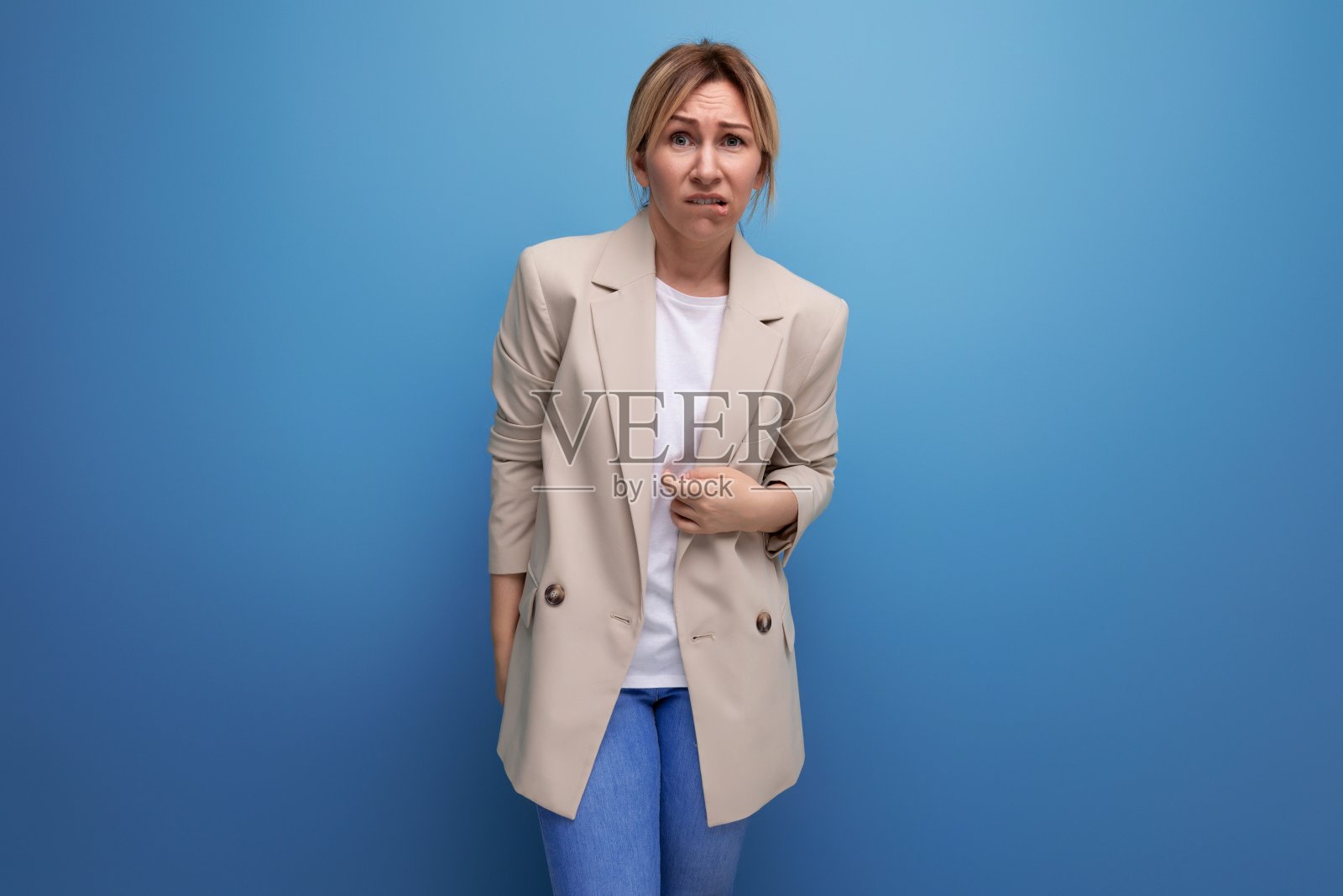 积极的金发年轻女子在休闲风格的工作室背景照片摄影图片