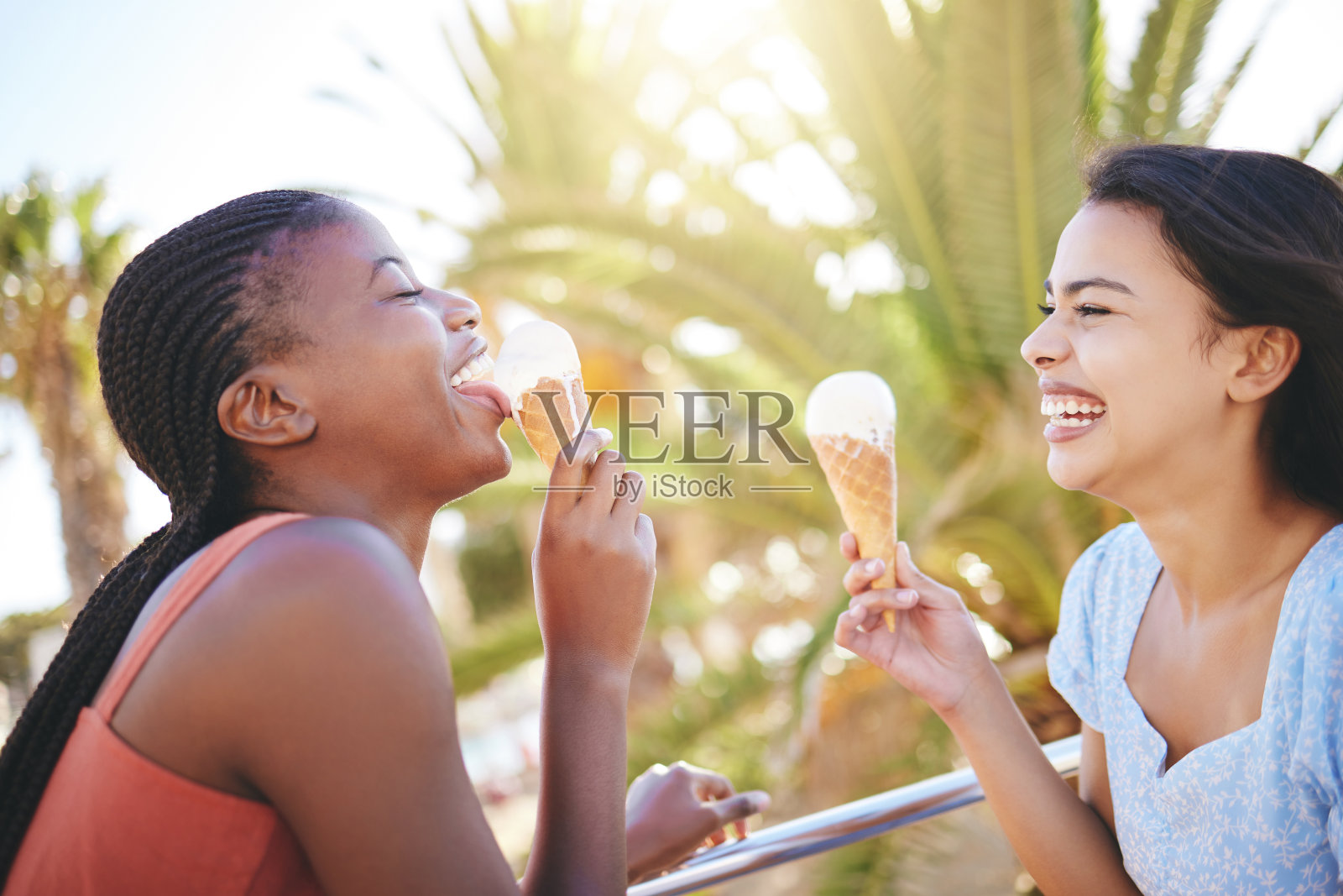 在沙滩上开怀大笑，和朋友一起吃冰淇淋，一起度假或旅行。幸福、快乐和闺蜜们在海边或海边的大自然中吃甜点。照片摄影图片