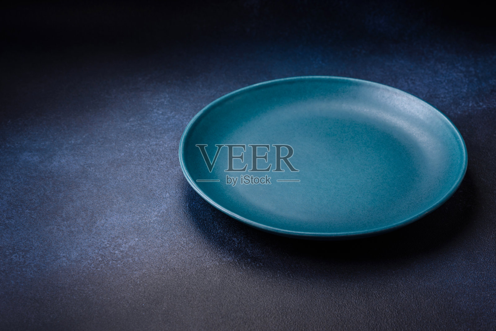 圆形空彩色陶瓷板在混凝土纹理背景照片摄影图片