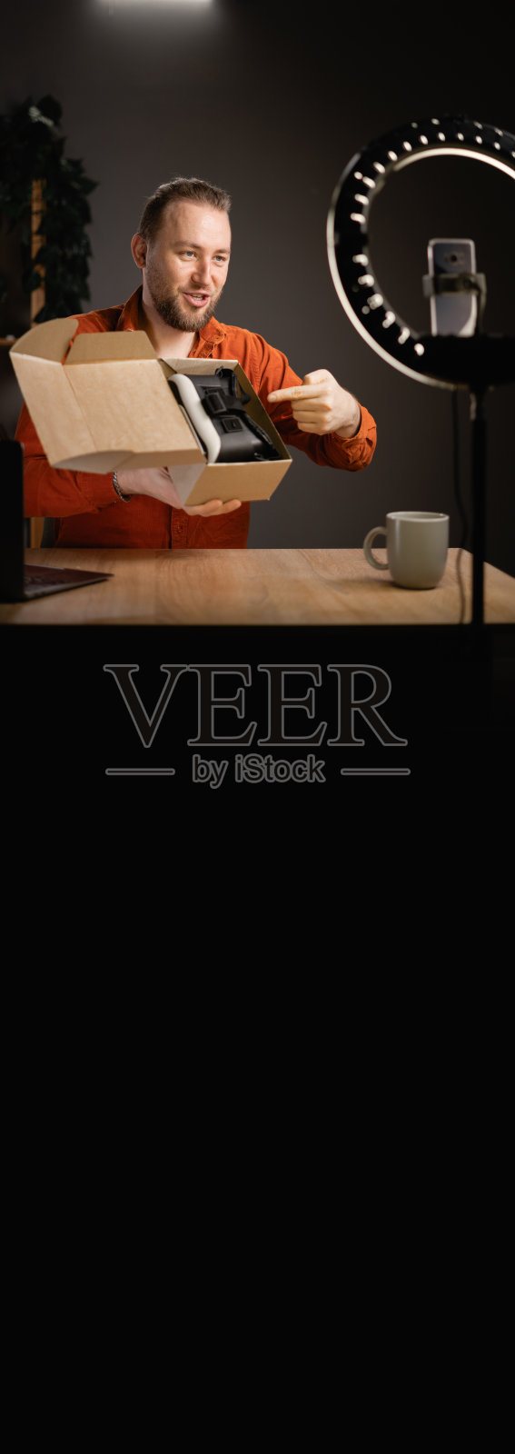 有魅力的千禧一代为自己的科技频道制作在线内容，每日视频博客，在家里打开新的VR眼镜，在线销售。照片摄影图片