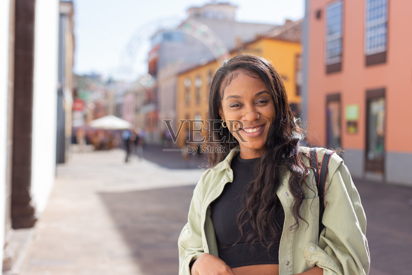 年轻的非洲妇女走在城市街道上看着相机的肖像照片摄影图片
