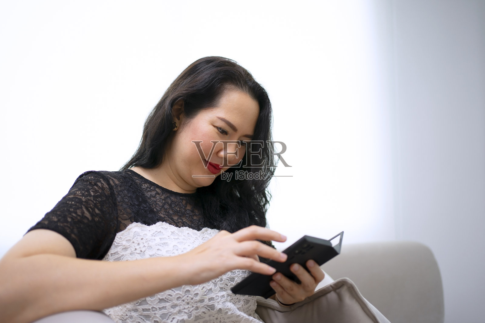 漂亮女人通过智能手机查找信息。照片摄影图片