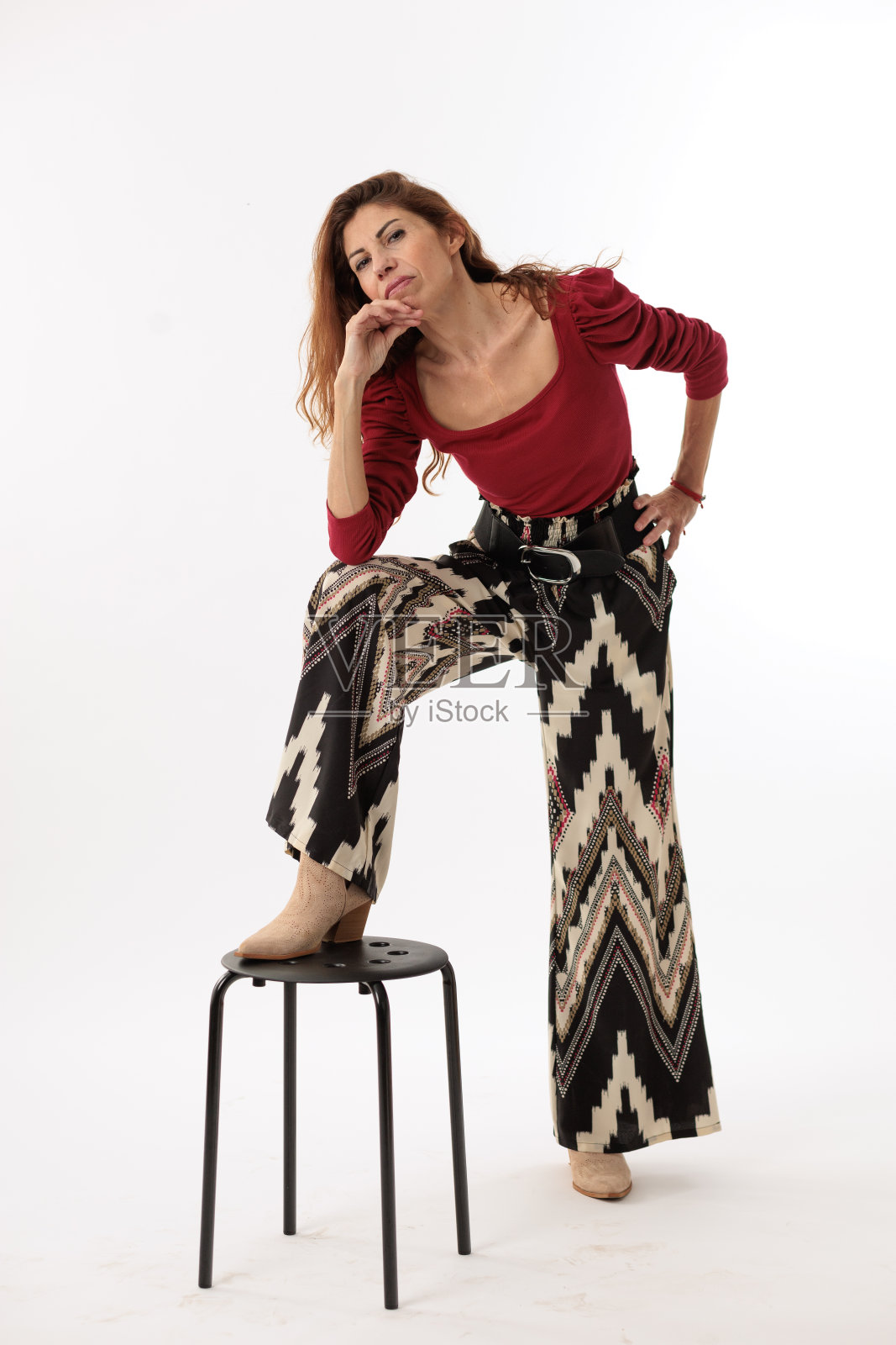 穿着白色背景的裤子和红衬衫的模特女人照片摄影图片