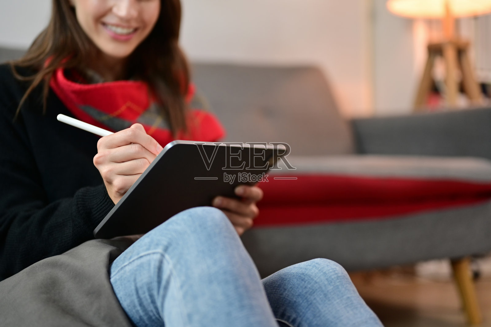 快乐的女性自由职业者写笔记，在舒适的家里用电子设备在线工作照片摄影图片