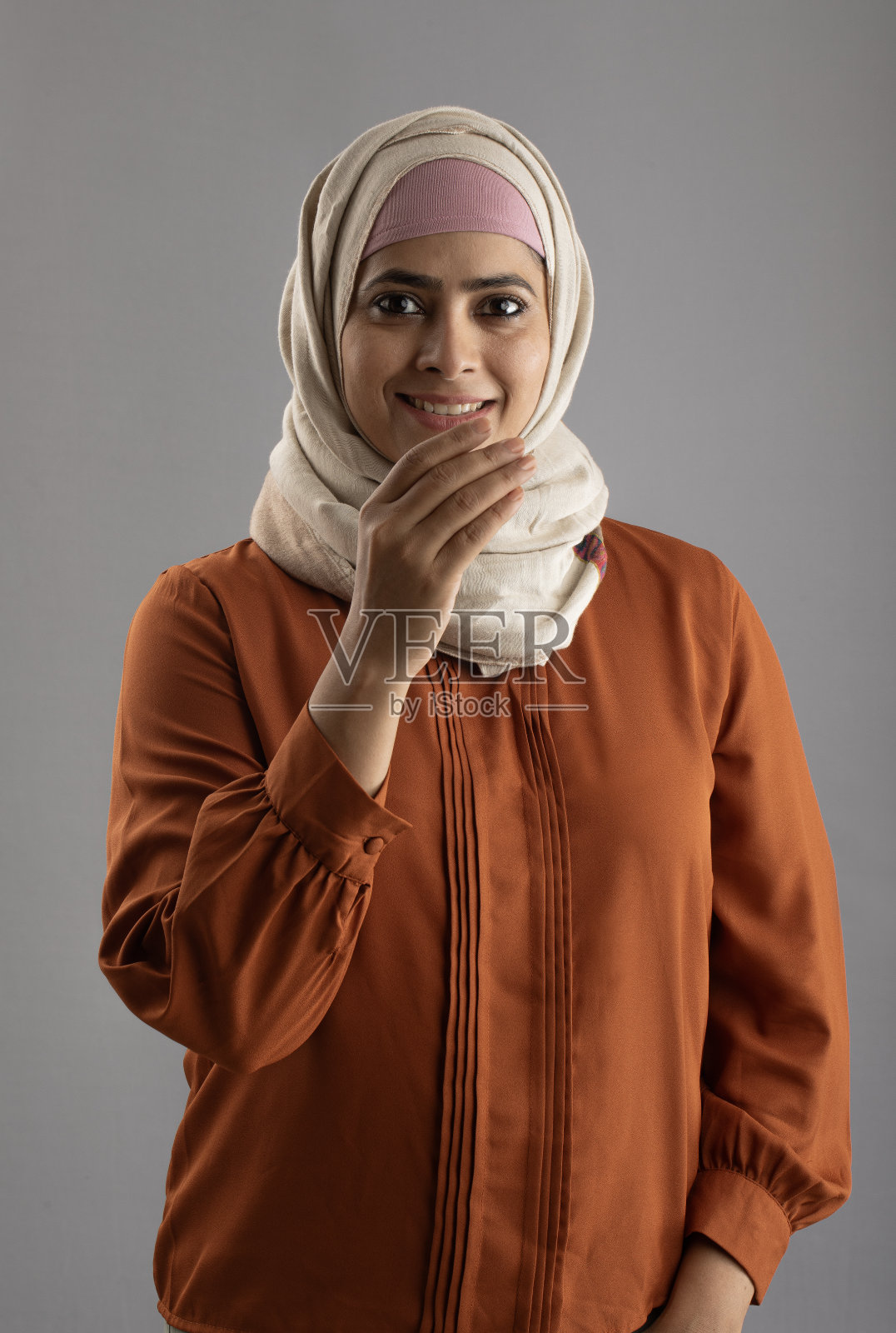 戴头巾的妇女在灰色背景上问候阿达布照片摄影图片