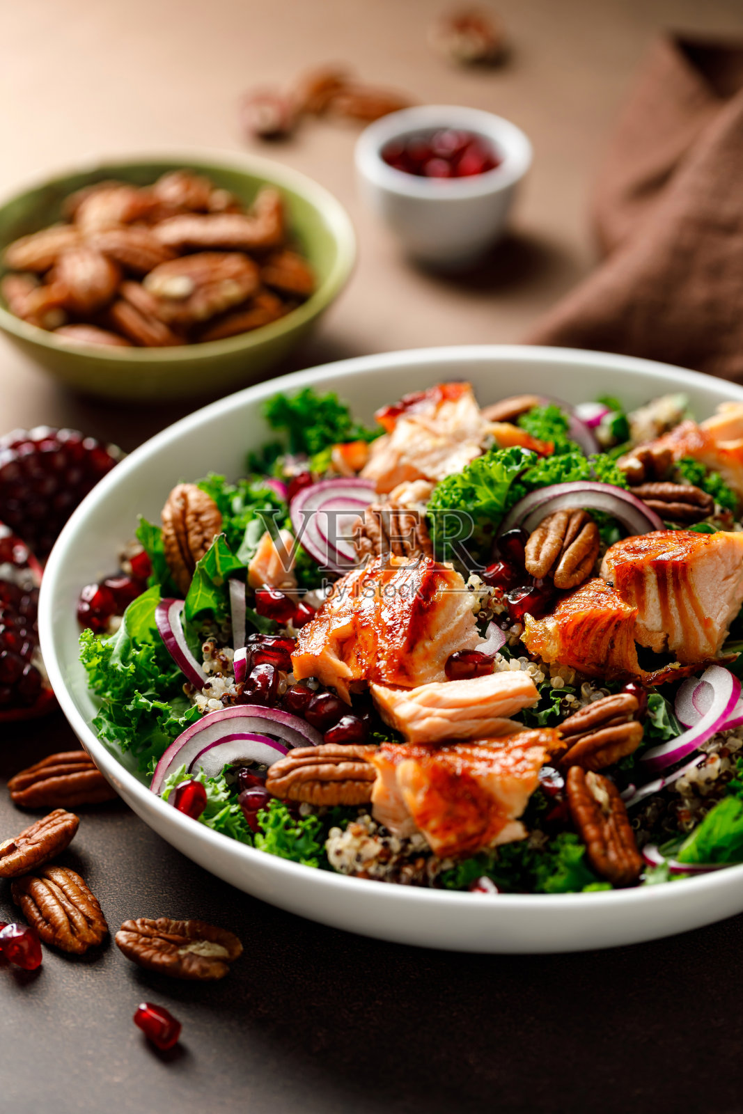 三文鱼沙拉配烤鱼，羽衣甘蓝，藜麦，山核桃，红洋葱和石榴照片摄影图片