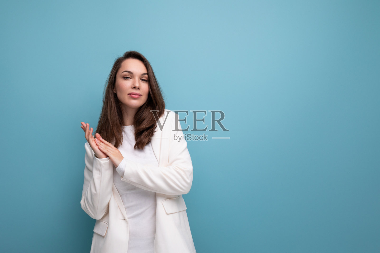 成功的黑发女人，穿着裙子和夹克，上面有蓝色的文案照片摄影图片