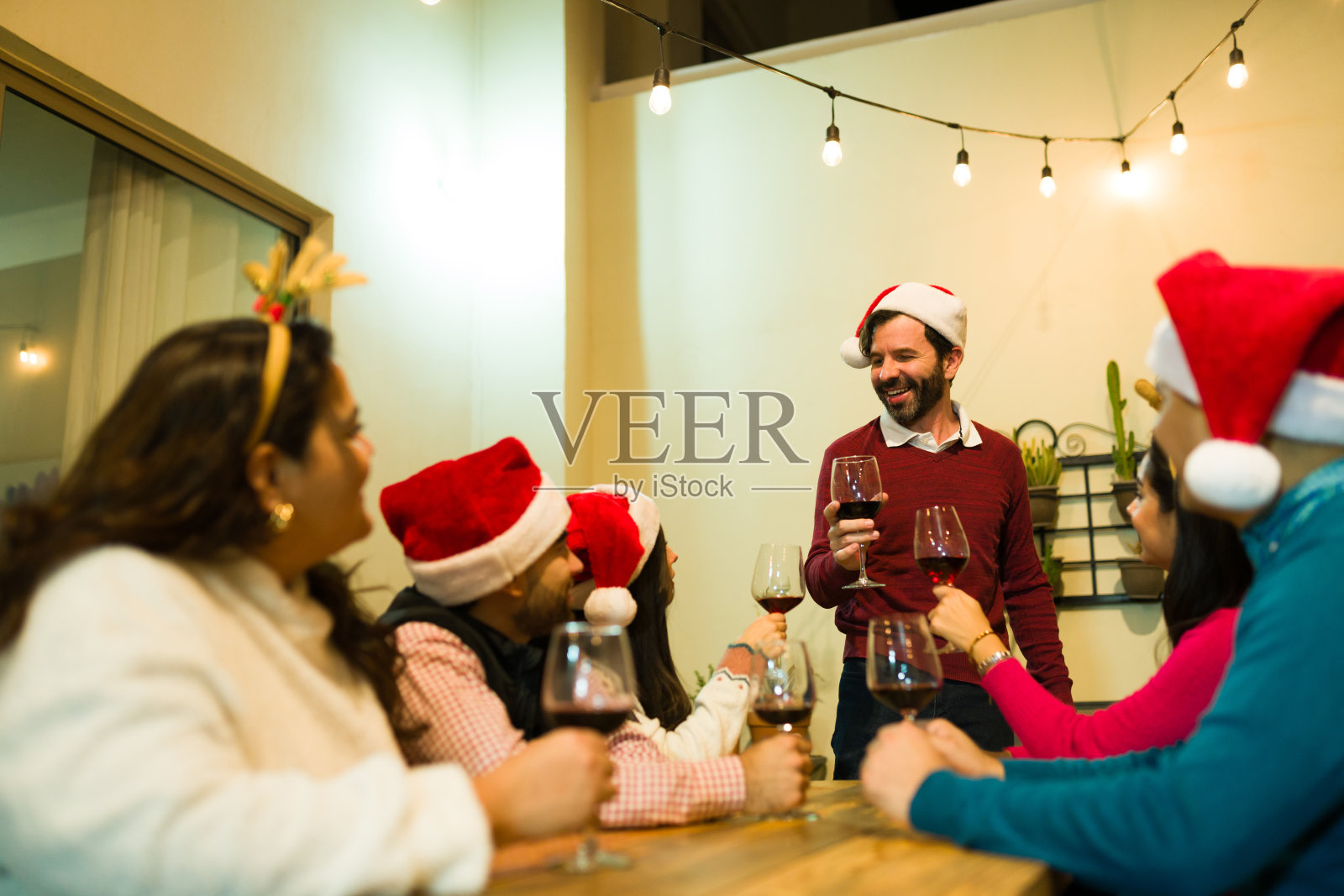 一群快乐的六个朋友一起庆祝圣诞晚餐照片摄影图片