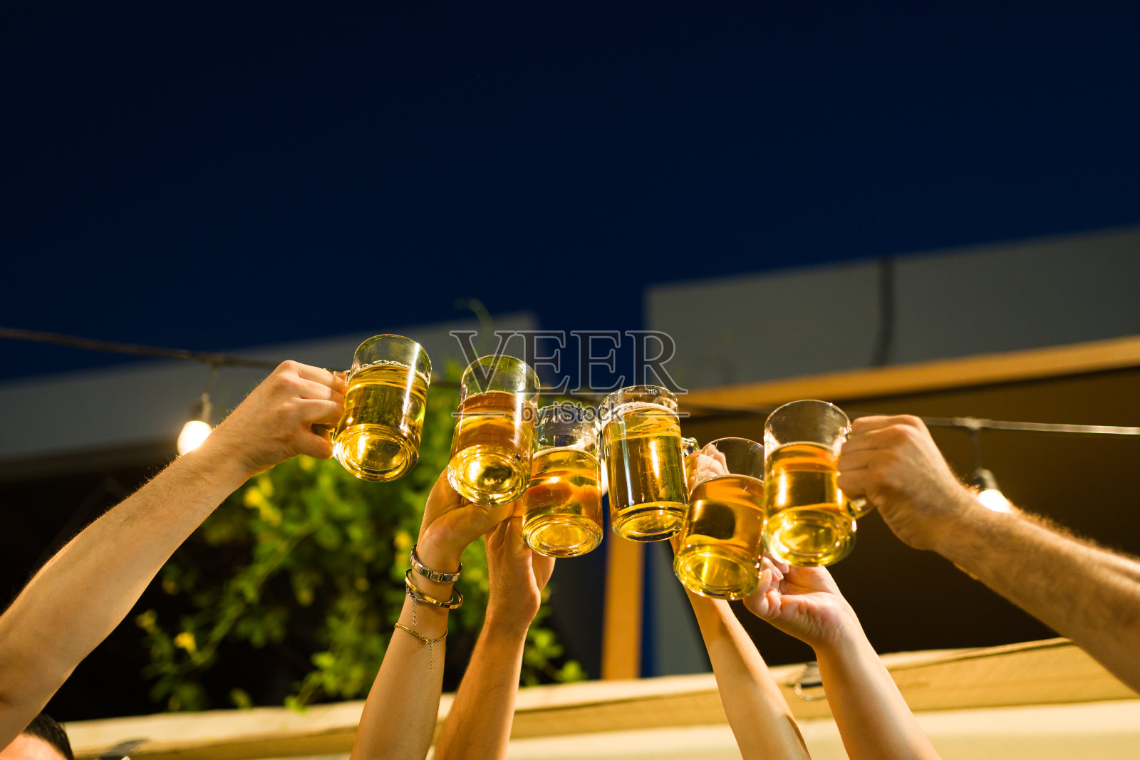 快乐的拉丁朋友在晚上喝啤酒照片摄影图片