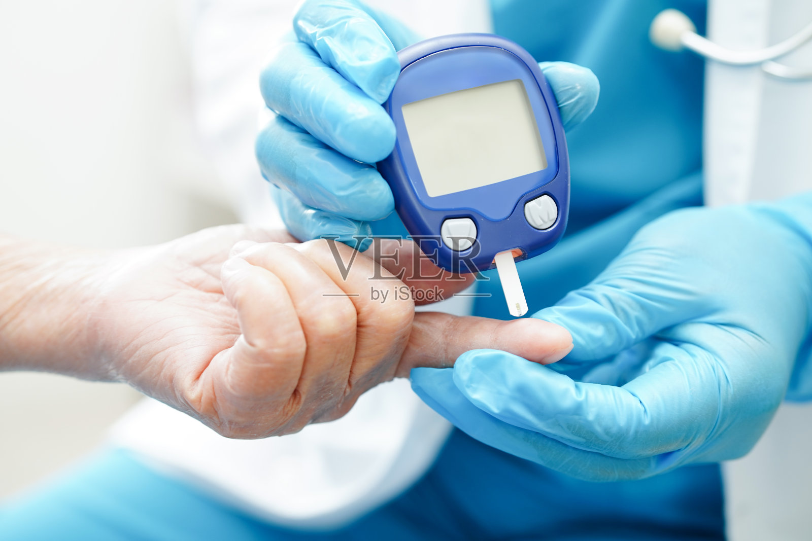 亚洲医生使用数字血糖仪检查样本血糖水平来治疗糖尿病。照片摄影图片