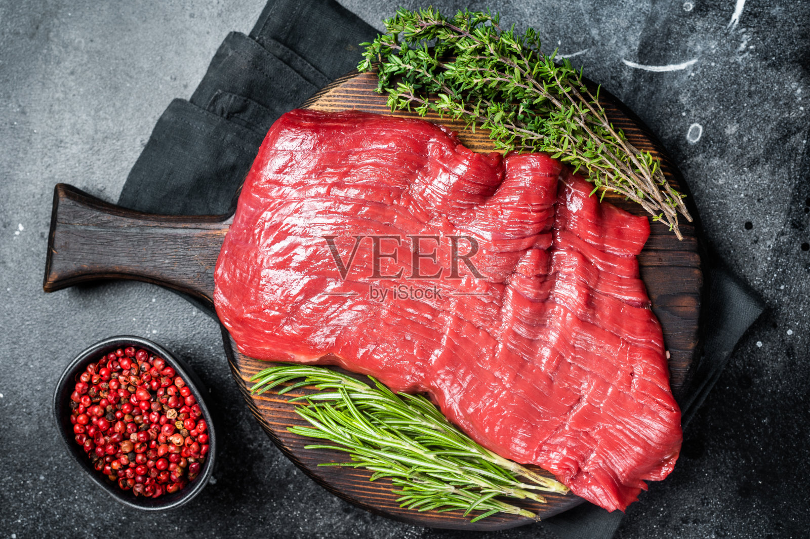生牛腩牛排，生肉加香草。黑色背景。俯视图照片摄影图片