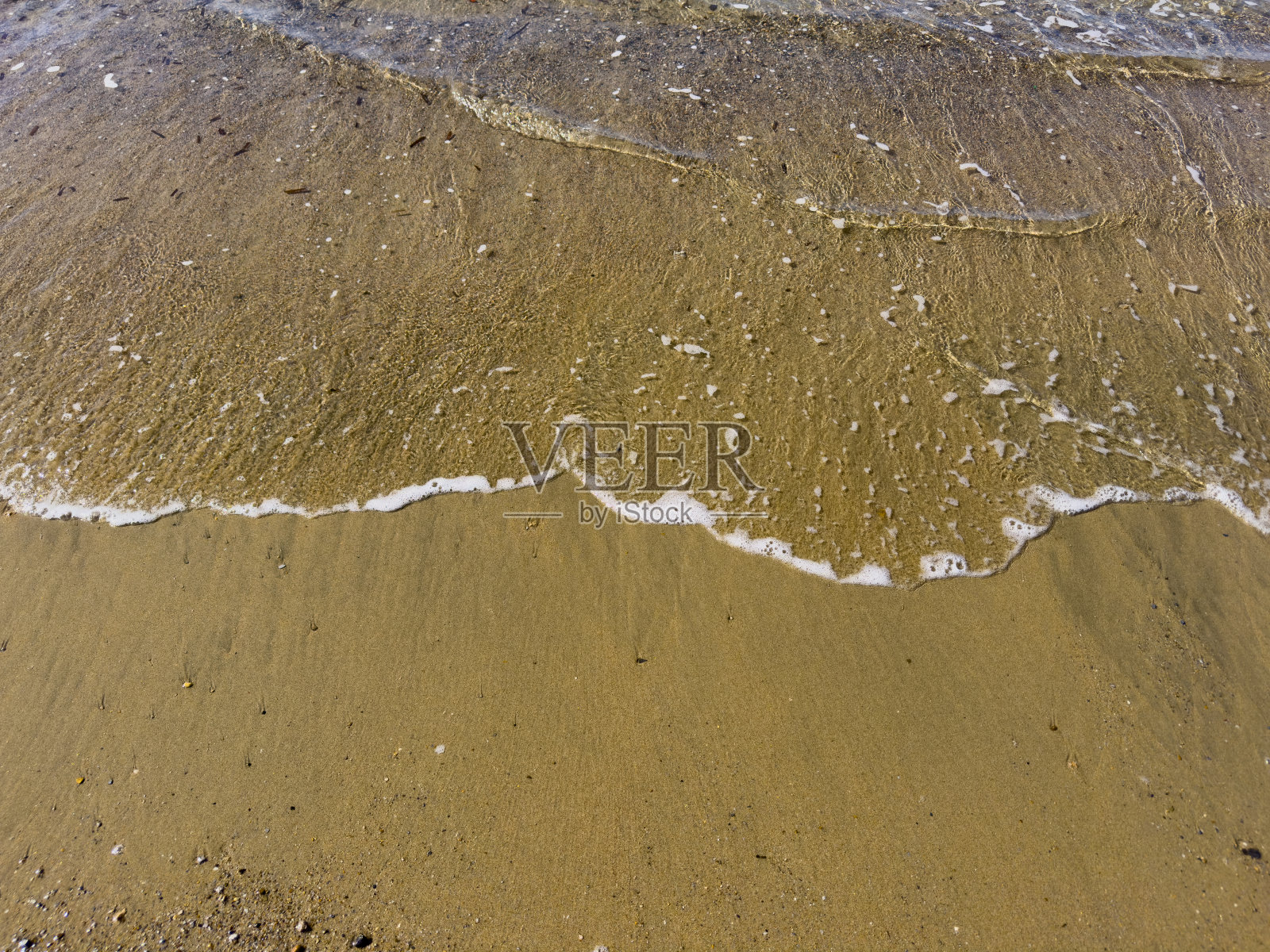 在阳光明媚的日子里，海浪涌向空旷的海滩。没有人。照片摄影图片