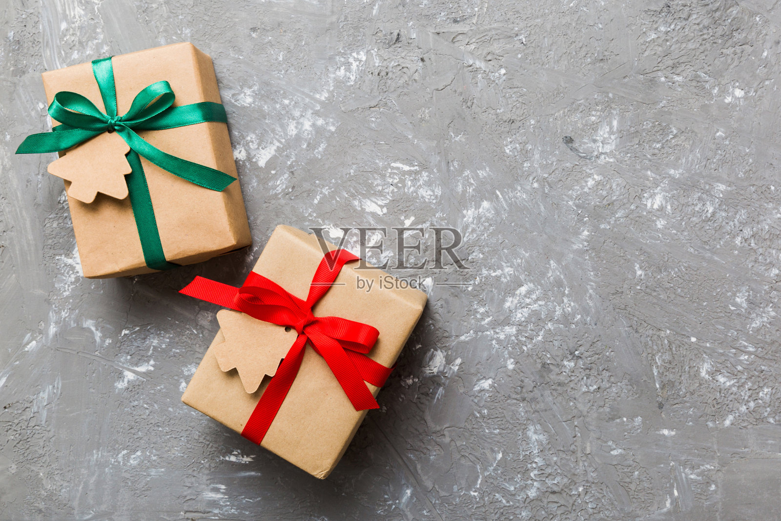 用彩带把圣诞节或其他节日手工制作的礼物用纸包好。礼品盒，彩色桌子上的礼品装饰，顶部视图与复制空间照片摄影图片