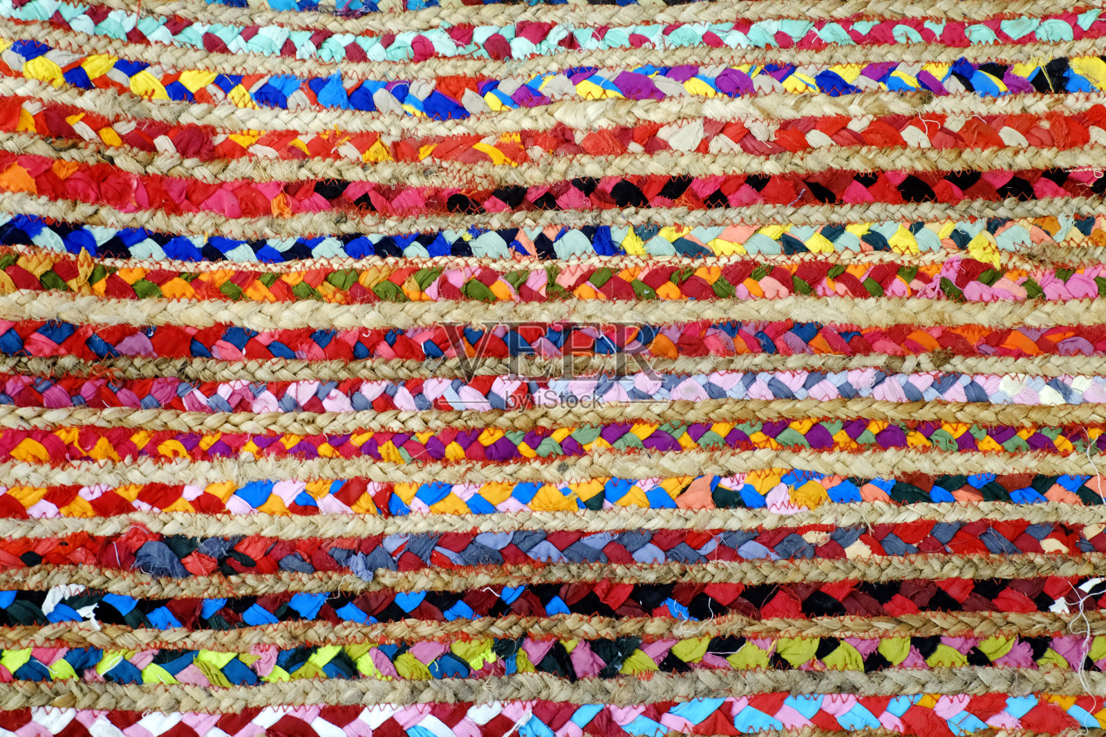 在克什米尔浦那举行的地毯展上，地毯正在被卷起来并展出。印度制造的印花真丝地毯，一叠五颜六色的高质量地毯。照片摄影图片