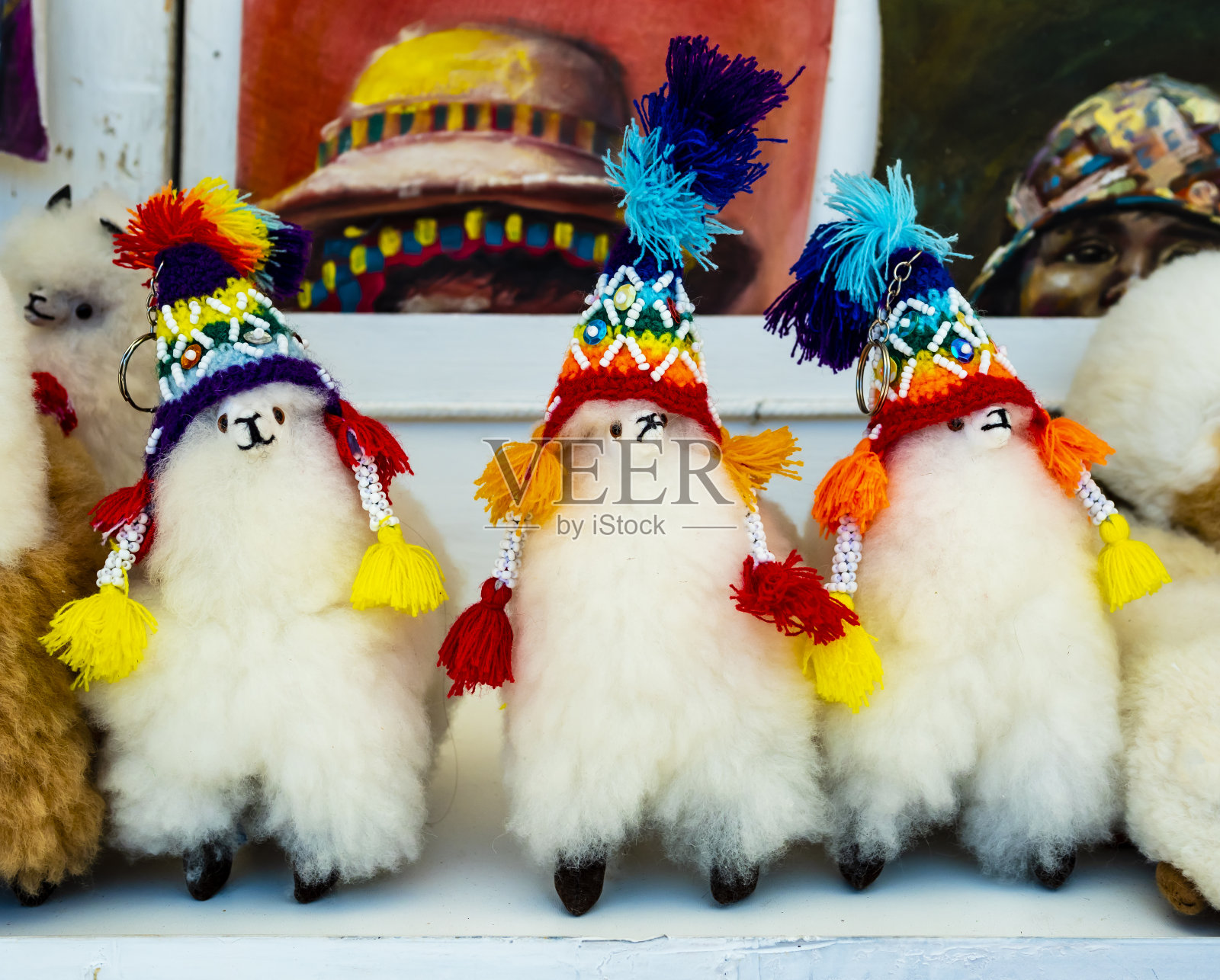 秘鲁Pisac传统市场，一排带着传统彩虹色帽子的羊驼毛绒玩具照片摄影图片