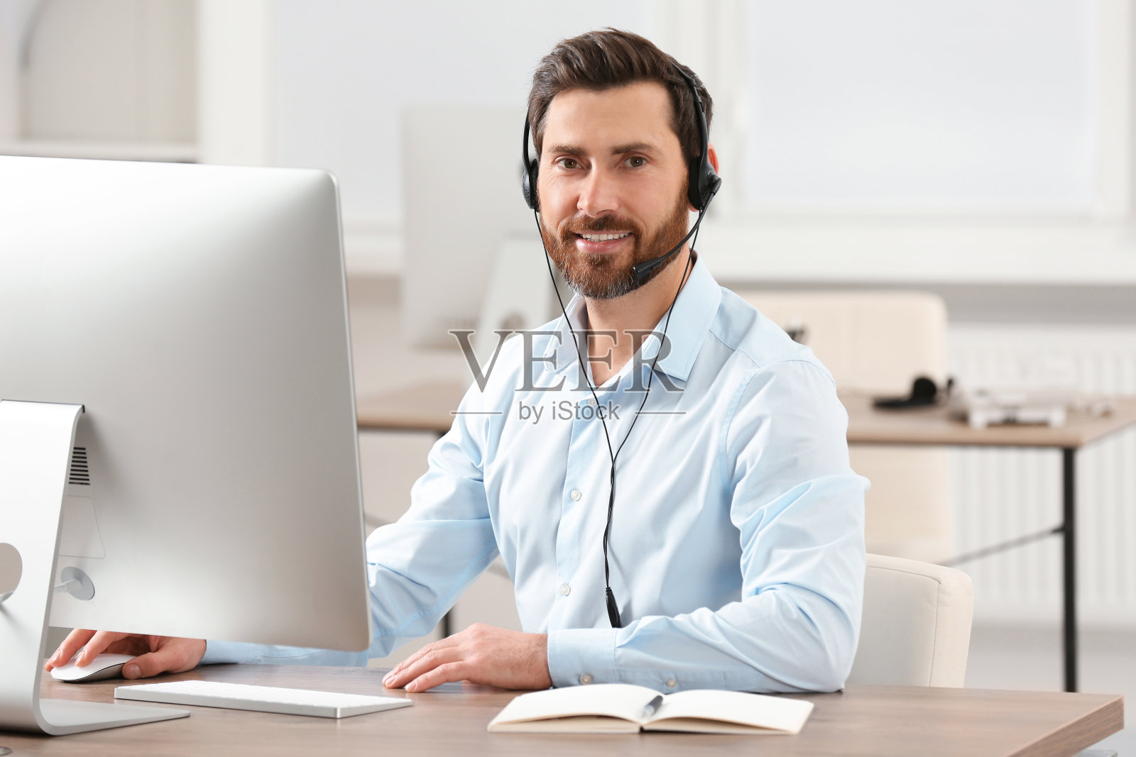 带耳机的热线话务员在办公室工作照片摄影图片