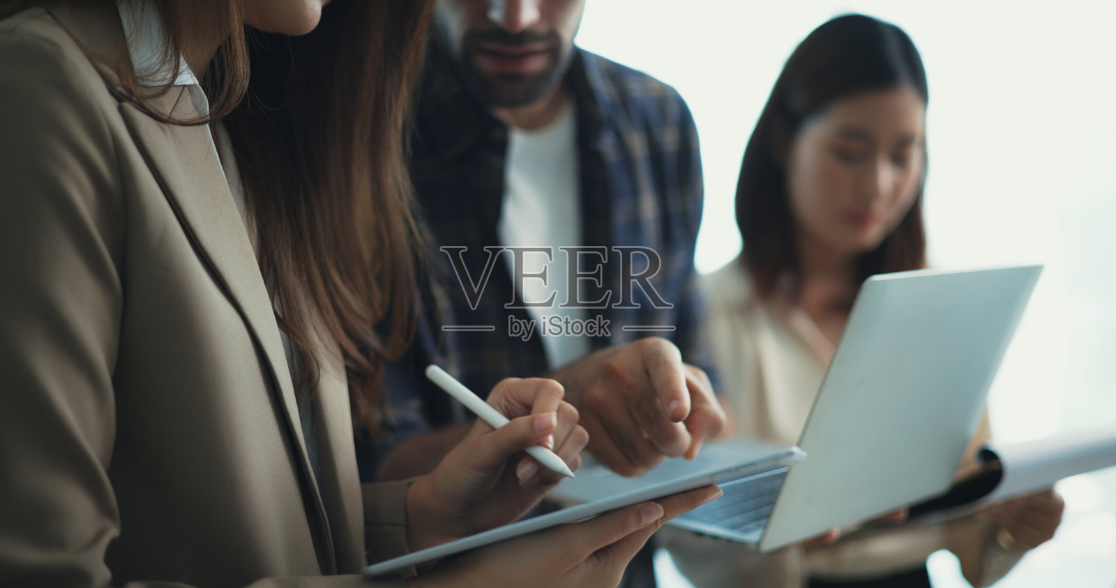 一群不同的商务人士在一个现代化的工作空间里使用笔记本电脑一起工作照片摄影图片