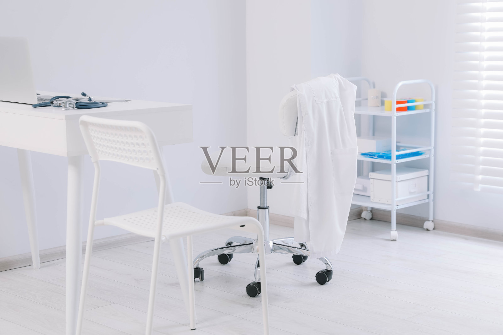 白色医生的长袍挂在诊所的椅子上照片摄影图片