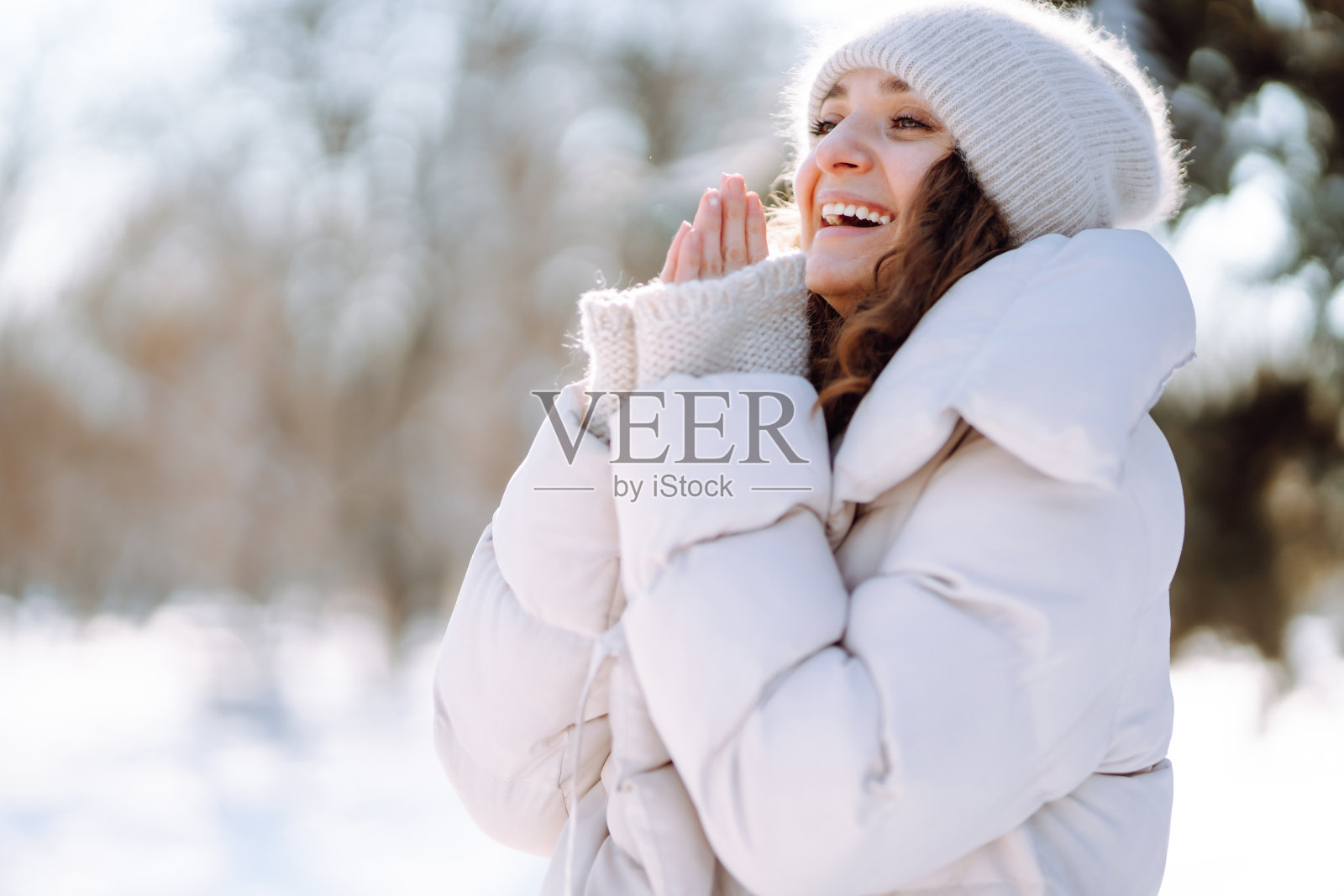 一个快乐的女人在下雪的冬日走在户外。照片摄影图片