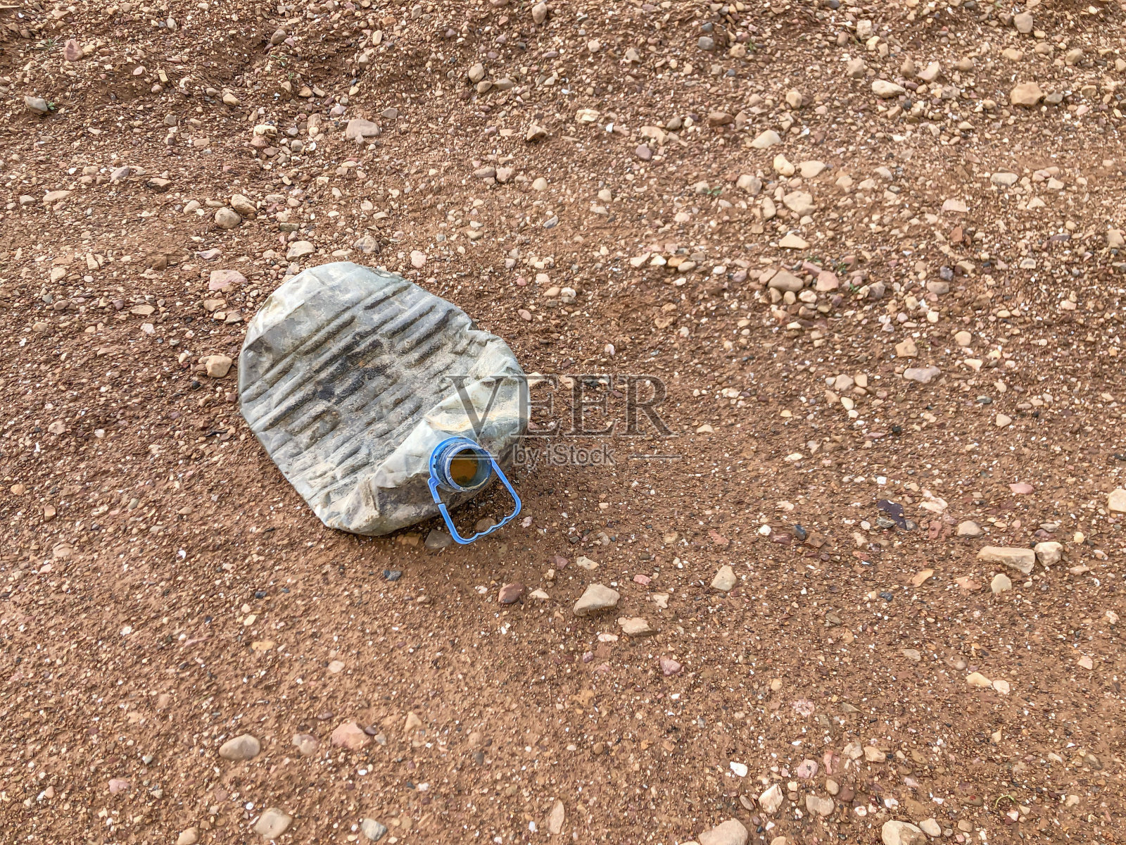 把塑料瓶倒空，放在干燥的土壤上，留出复制空间照片摄影图片