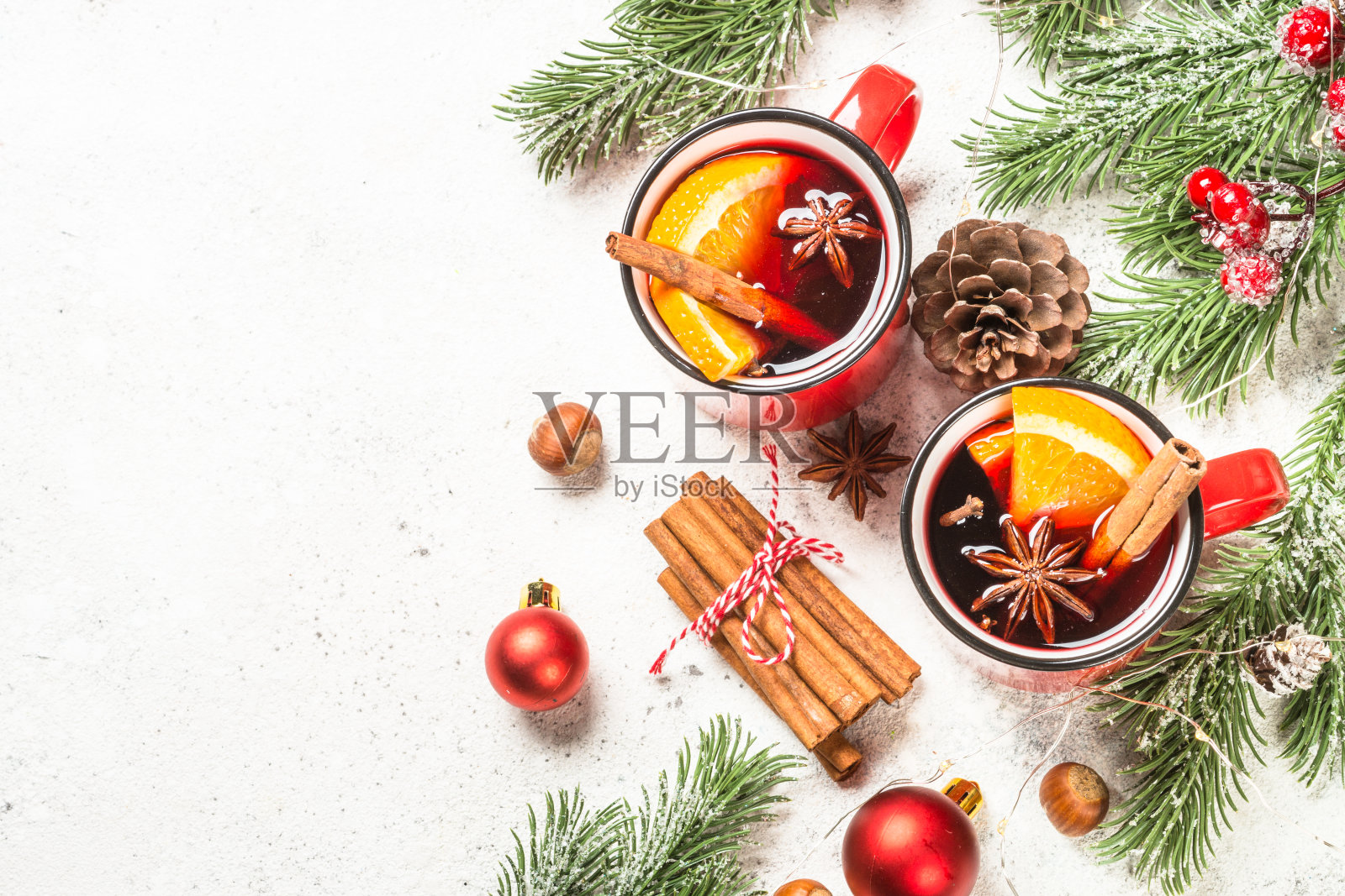 用红色杯子盛着圣诞装饰的热红酒。照片摄影图片