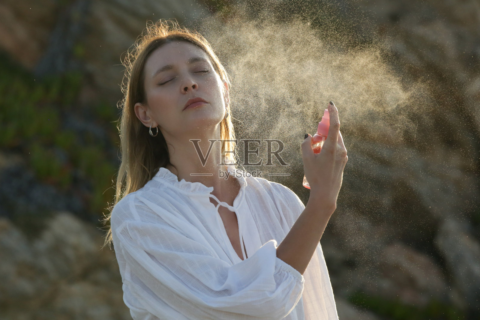 女士在脸上喷洒面部喷雾，夏日护肤概念照片摄影图片