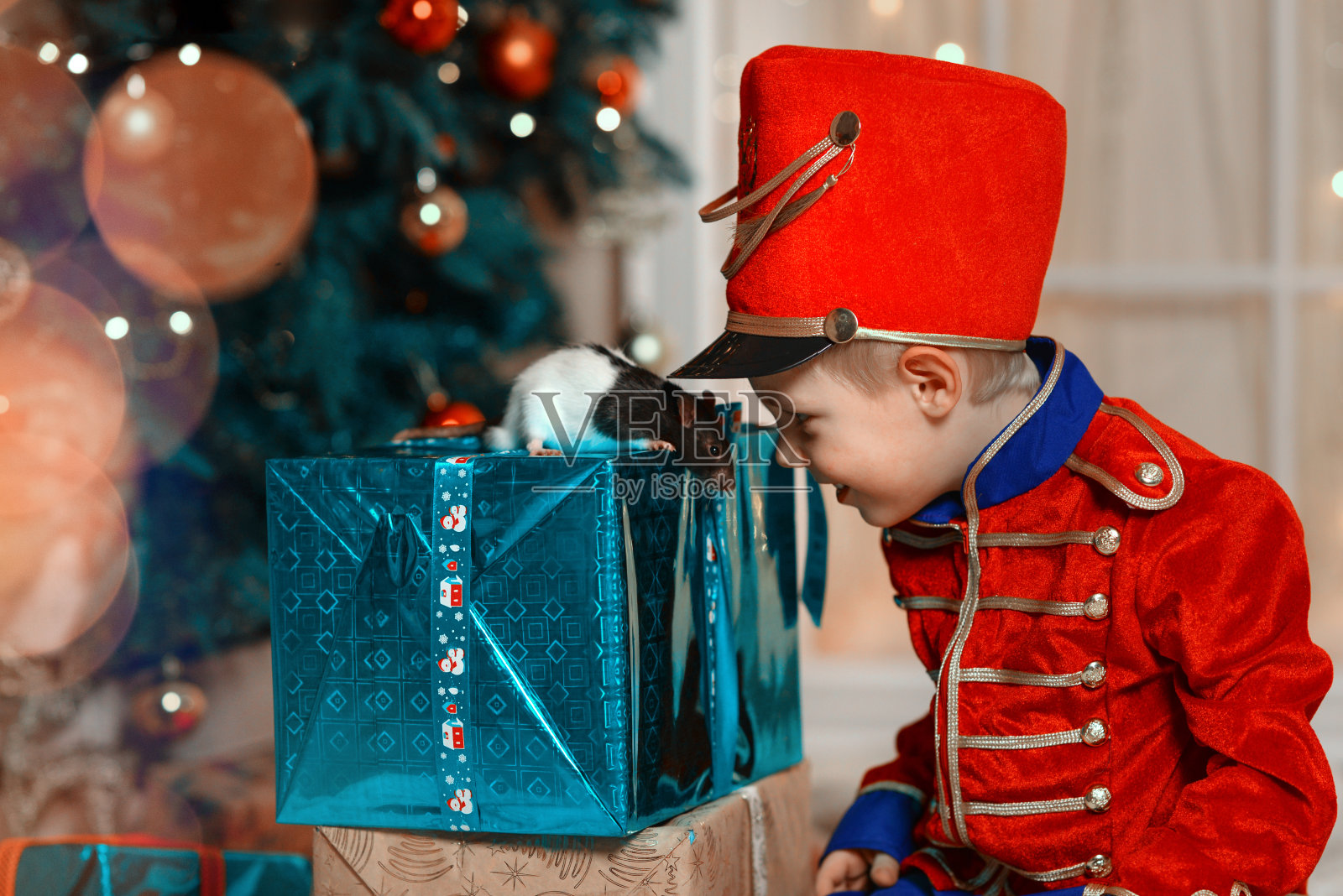 一个穿着胡桃夹子服装的男孩玩弄着这一年的象征老鼠。照片摄影图片