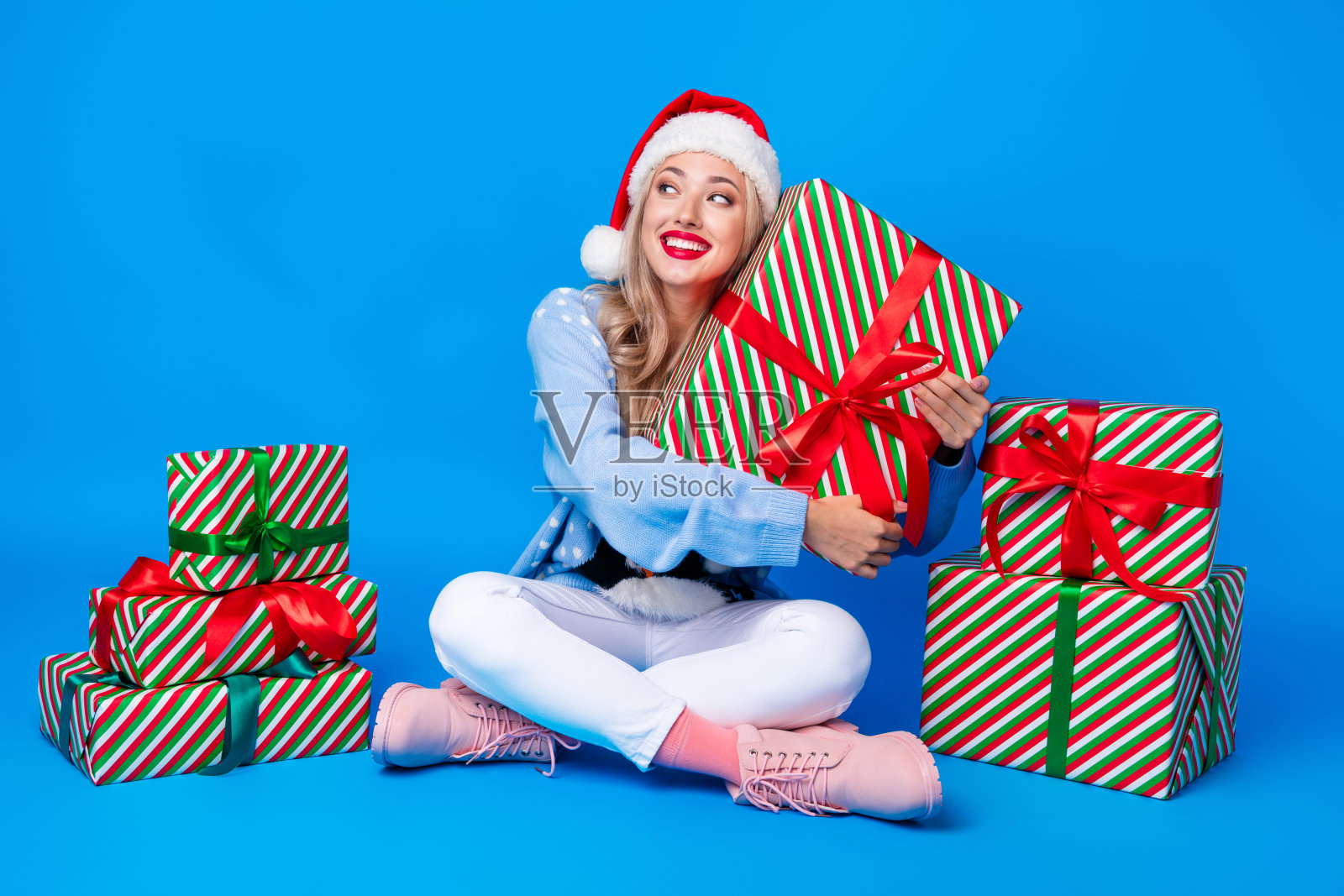 身材丰满的年轻女士干部拥抱礼盒惊喜新年快乐季节销售看愿望清单模型孤立的蓝色背景照片摄影图片
