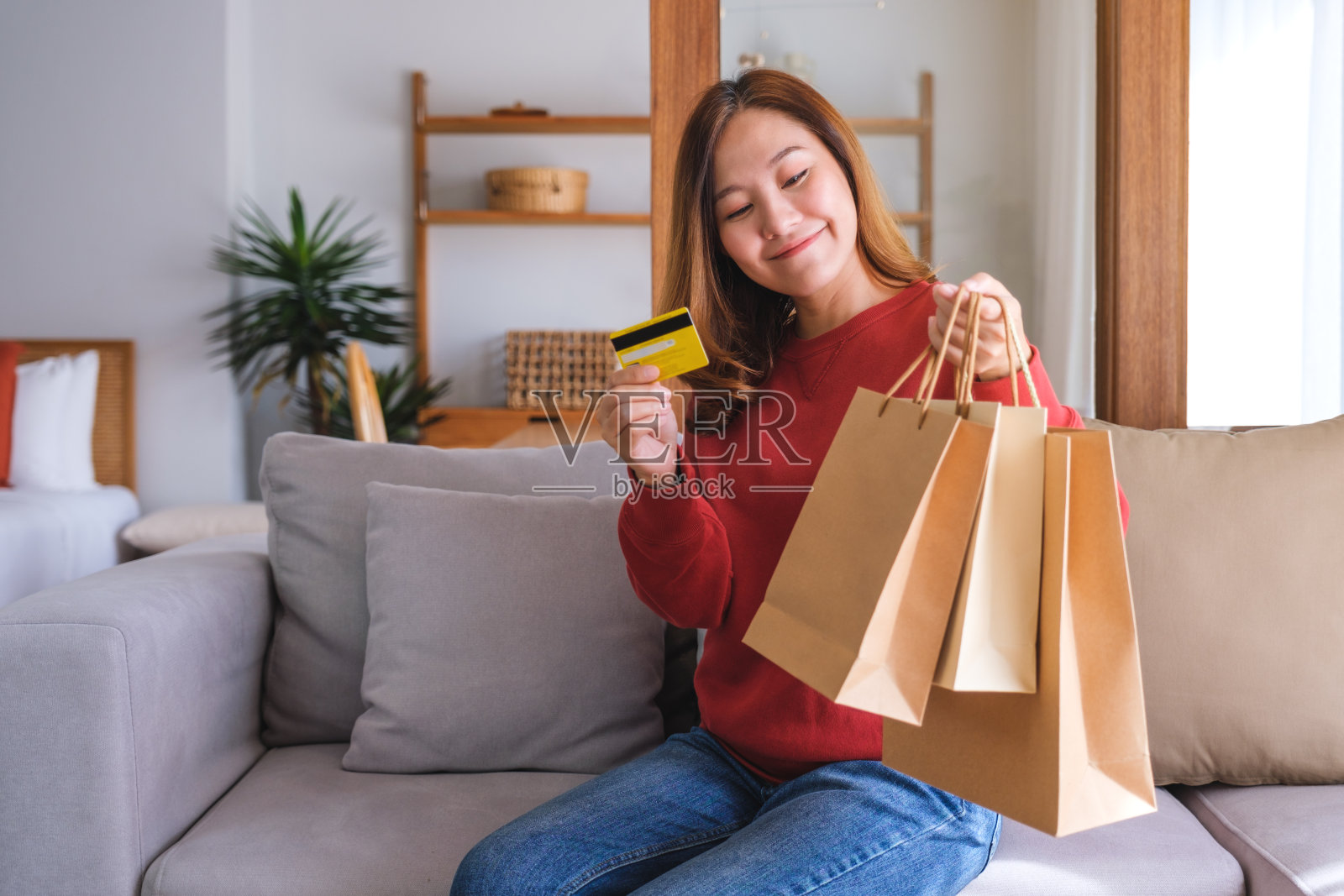 一名女子手持信用卡和购物袋照片摄影图片