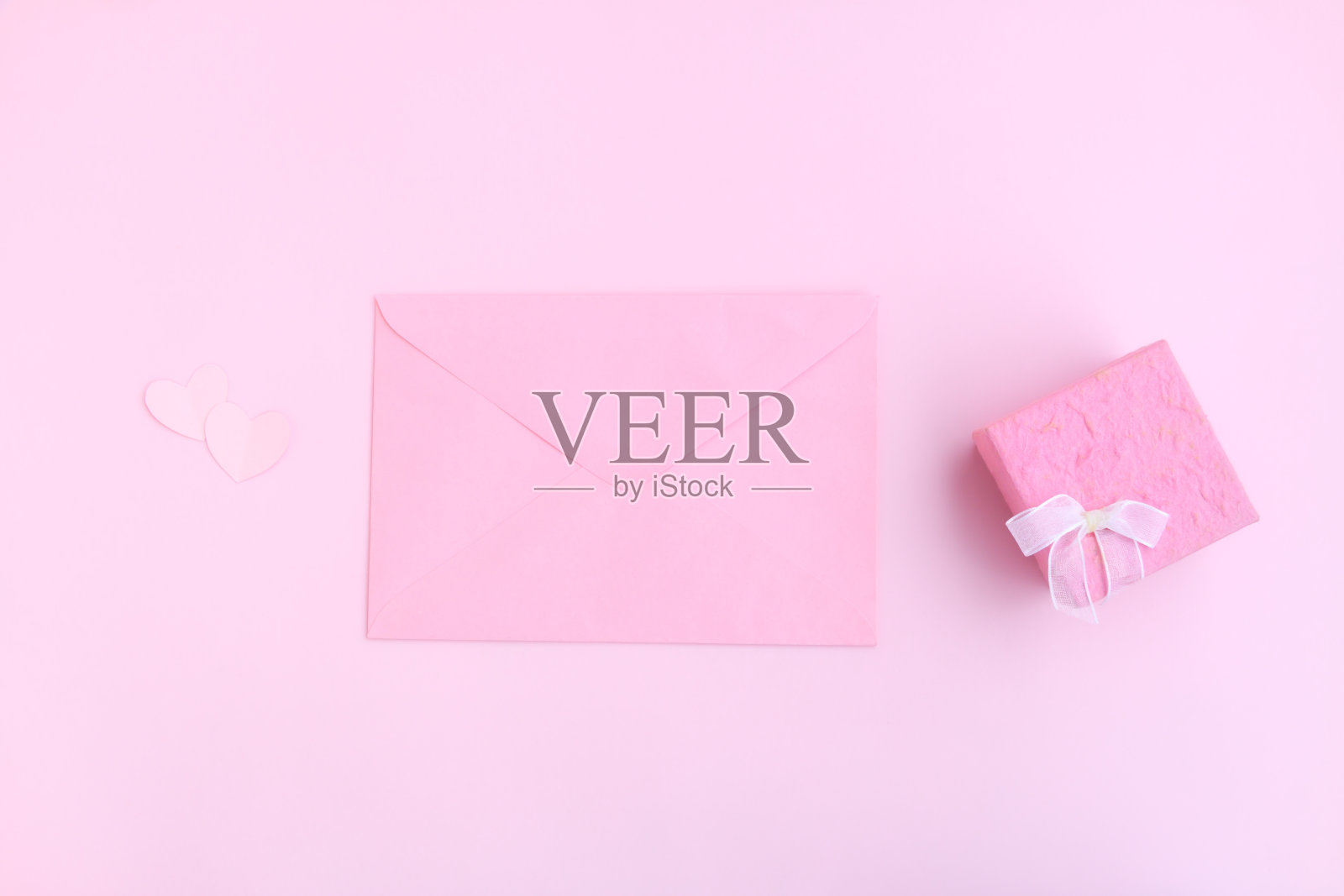 粉红色信封，粉红色礼盒和粉红色心形剪纸粉红色的背景，爱和情人节的概念照片摄影图片